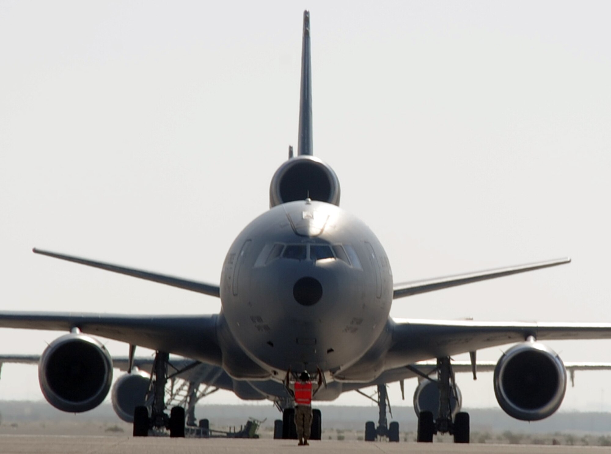 A maintenance Airmen provides direction to a KC-10 Extender as it moves out for a combat air refueling mission during operations on the flightline at a non-disclosed base in Southwest Asia on Jan. 22, 2009. The KC-10, assigned to the 908th Expeditionary Air Refueling Squadron, is one of Air Mobility Command's air refueling aircraft deployed to the U.S. Central Command area of responsibility that provides the "global reach" for Air Force and Department of Defense aircraft through air refueling operations for Operations Iraqi Freedom and Enduring Freedom and the Combined Joint Task Force-Horn of Africa. (U.S. Air Force Photo/Tech. Sgt. Scott T. Sturkol/Released)