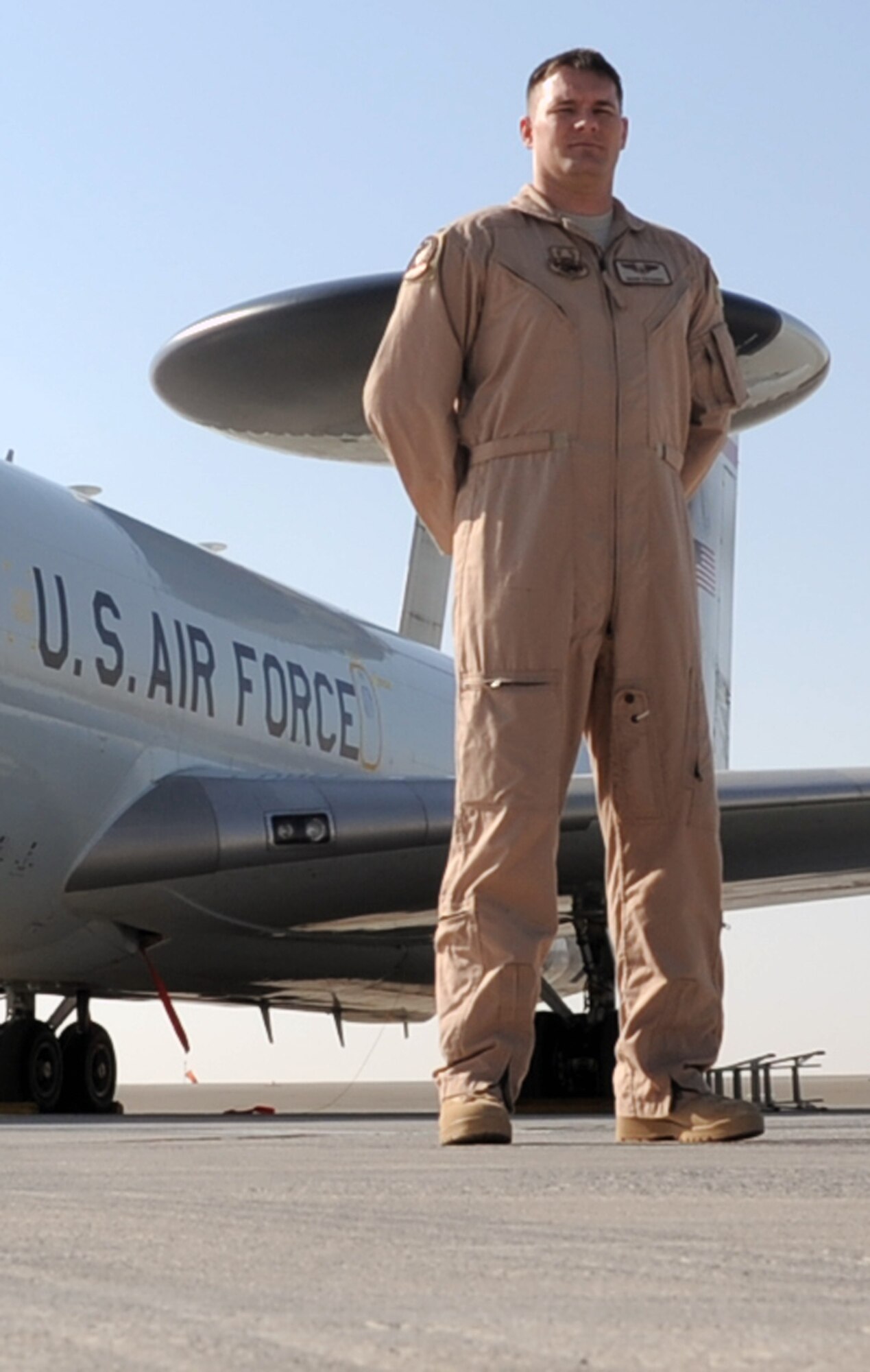 First Lt. Sean Fazande is an air weapons officer with the 965th Expeditionary Airborne Air Control Squadron at a non-disclosed base in Southwest Asia. Here he is pictured with the main airframe, the E-3 Sentry Airborne Warning and Control System aircraft, that he flies on to do is job. Deployed from the 965th AACS at Tinker Air Force Base, Okla., the lieutenant is a prior U.S. Navy aircraft mechanic who became an Air Force officer. The lieutenant's hometown is Destrehan, La.  (U.S. Air Force Photo/Tech. Sgt. Scott T. Sturkol/Released) 