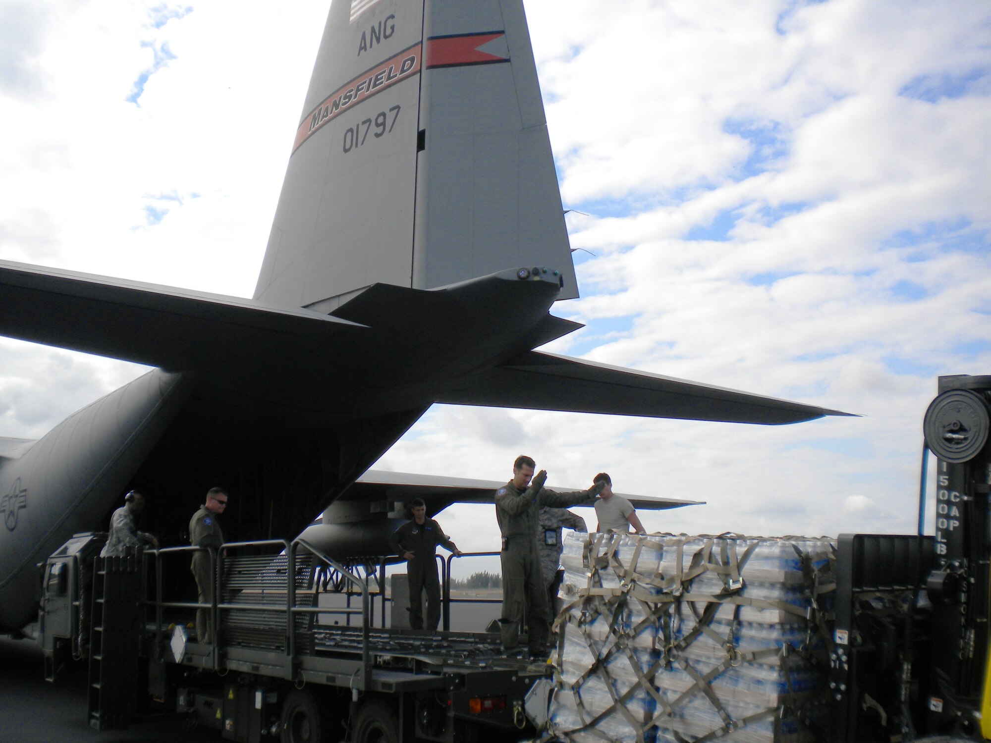 Airmen from the Mansfield-based 179th Airlift Wing load bottled water onto a C-130 "Hercules" cargo aircraft Jan. 19, 2010, at Homestead Air Reserve Base, Florida, during relief efforts following a magnitude 7.0 earthquake Jan. 12 that devastated the capital city of Port-au-Prince, Haiti. The Airmen, who were deployed to Puerto Rico in support of Operation Coronet Oak, a theater airlift support mission, were immediately diverted to conduct relief efforts.(courtesy photo)