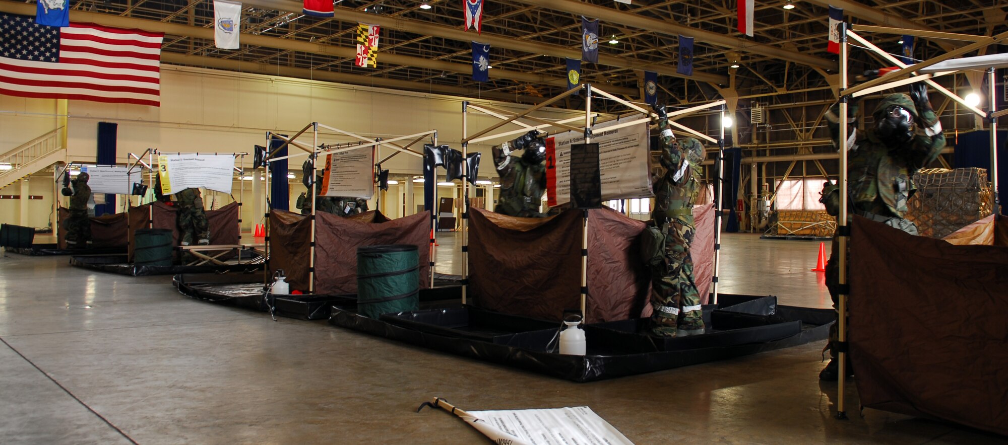 MISAWA AIR BASE, Japan--Airmen from across the base participate in building contamination control stations during a contamination control area exercise Jan. 21 in Hangar 949. Airmen built two sets of four stations. Each station focused on a different aspect of removing contamination from Airmen. (U.S. Air Force photo/Staff Sgt. Phillip Butterfield)
