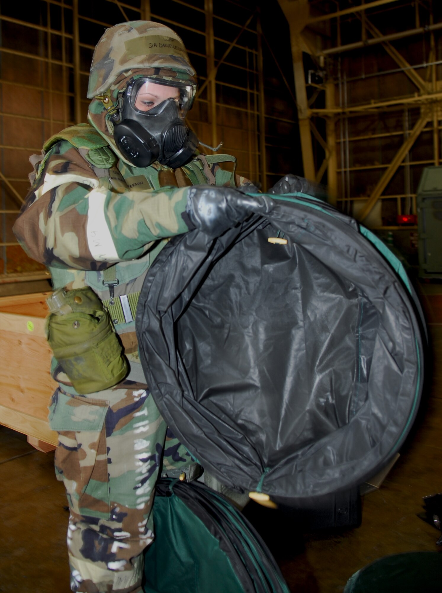 MISAWA AIR BASE, Japan--Senior Airman Danielle Epperson, 35th Communications Squadron circuit actions technician, opens a contaminated clothing collection barrel during a contamination control area exercise Jan. 21 in Hangar 949. The 35th Civil Engineer Squadron Emergency Management Flight conducted the exercise to ensure Airmen were ready for the upcoming operational readiness exercise. (U.S. Air Force photo/Staff Sgt. Phillip Butterfield)