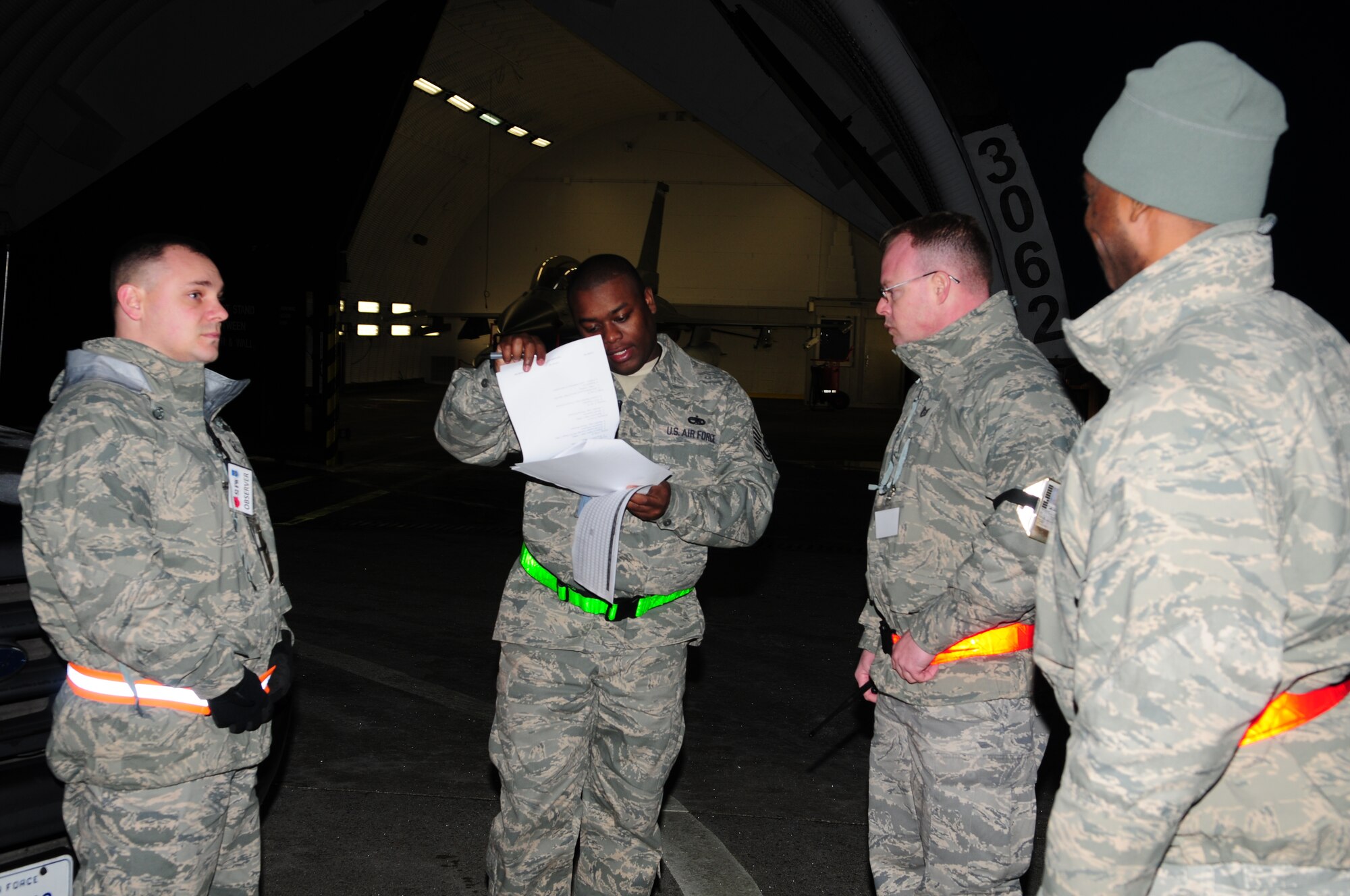 SPANGDAHLEM AIR BASE, Germany -- Master Sgt. Dave Hatch, Tech. Sgt. Marcus Donald, Tech Sgt. Marcus Collins and Tech Sgt. Deke Stacy, exercise evaluation team members, discuss the plan for assessing an F-16 Fighting Falcon generation order during Operation Saber Crown 10-3.  The exercise tested the base’s capability to respond to a real-world emergency by deploying aircraft, people and cargo.  (U.S. Air Force photo/Staff Sgt. Heather M. Norris)
