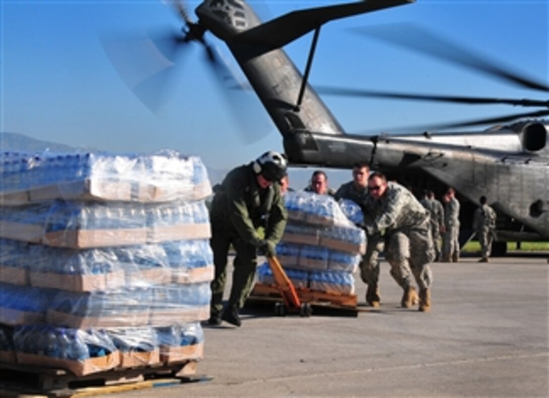 U.S. Army soldiers help the crew of a Navy MH-53E Sea Dragon helicopter from the aircraft carrier USS Carl Vinson (CVN 70) unload food and supplies at the airport in Port-au-Prince, Haiti, on Jan. 15, 2010.  The U.S. military is conducting humanitarian and disaster relief operations after a 7.0-magnitude earthquake caused severe damage in and around Port-au-Prince on Jan. 12, 2010.  