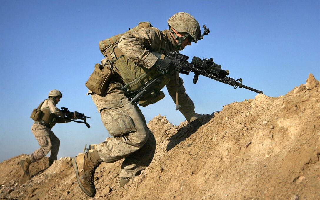 Company G Marine Lance Cpl. Zachariah P. Hogge, from Norfolk, Va., bounds over a dirt mound while practicing for a battalion live-fire exercise Jan. 22 on a military range here. Company G, Battalion Landing Team 2/4’s mechanized assault force, was practicing its part in a battalion-sized live-fire operation that was BLT 2/4’s largest as the 11th Marine Expeditionary Unit’s ground combat element.
