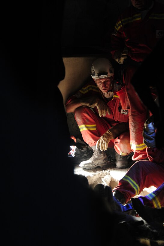 Members of various rescue teams work Jan. 19, 2010, in Port-au-Prince, Haiti, to free a 25-year-old Haitian woman who had been trapped for seven days in a space in a collapsed building. (U.S. Air Force photo/Tech. Sgt. James L. Harper Jr.)