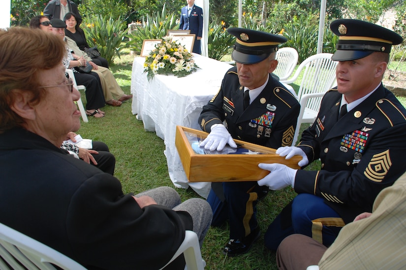 Command Sgt. Maj. Eloy Alcivar, Joint Task Force-Bravo Command Sergeant Major, and First Sgt. Mark Baker, 1/228th Aviation Regiment First Sergeant, present an American flag to Delis Soto, the Honduran mother of a fallen U.S. Soldier, during a memorial ceremony in Siguatepeque, Honduras, Jan 23. Danilo Soto, Jr. (Feb. 18, 1946 - Nov. 15, 2009) was an American citizen and Vietnam War veteran who served in the U.S. Army from 1966 to 1968. (U.S. Air Force photo by 1st Lt. Jen Richard)