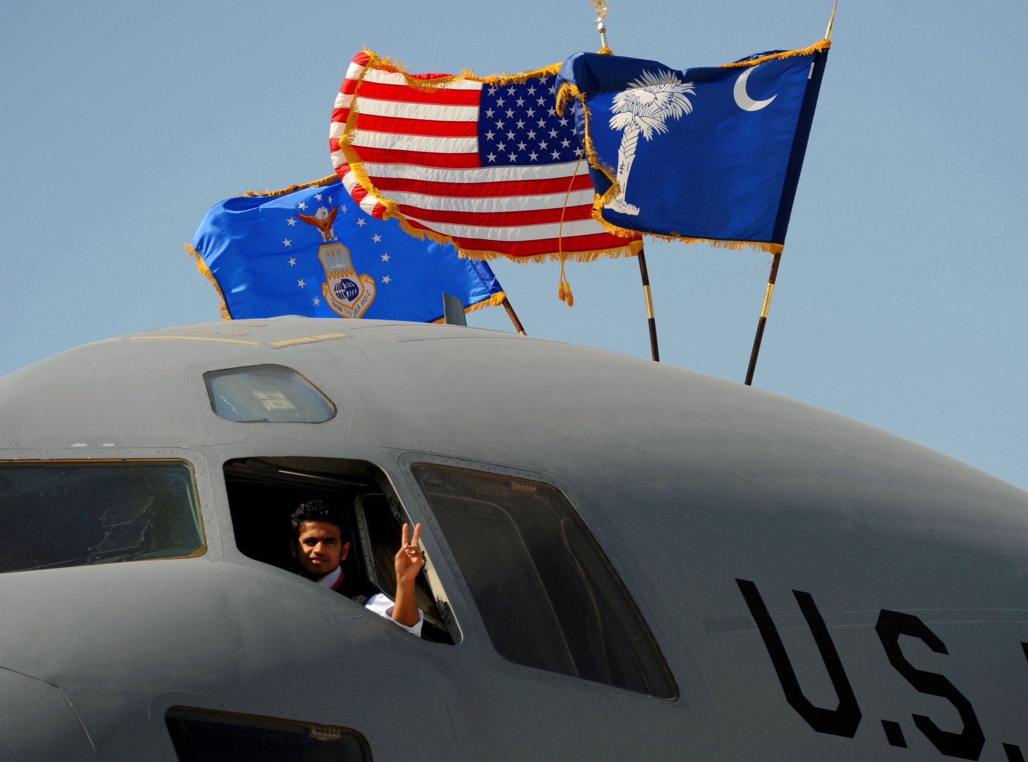A local Bahraini boy looks out of a U.S. Air Force C-17 Globemaster III while holding a "V for victory" gesture for his father during Bahrain's inaugural airshow, Jan. 23, 2010. (U.S. Air Force photo/Staff Sgt. Angelita Lawrence/released)

