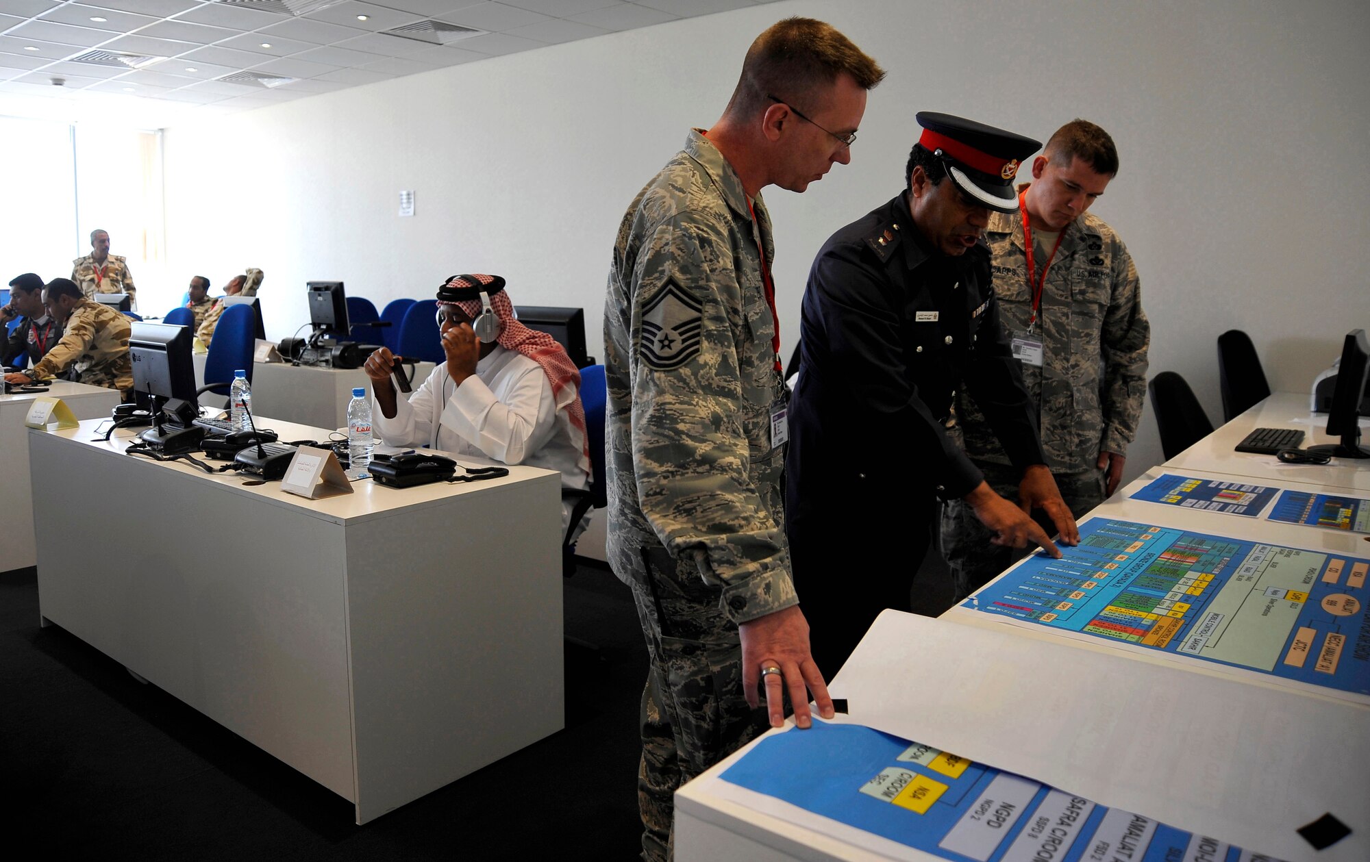 U.S. Air Force Senior Master Sgt. Daniel Zent, left, Air Force Forward emergency management program manager, and Master Sgt, Timothy Capp, right, Air Force Central Command emergency management functional-area manager, speak with a Bahraini civil-defense force member, during Bahrain's inaugural airshow, Jan. 23, 2010. (U.S. Air Force photo/ Staff Sgt. Angelita Lawrence/released)
