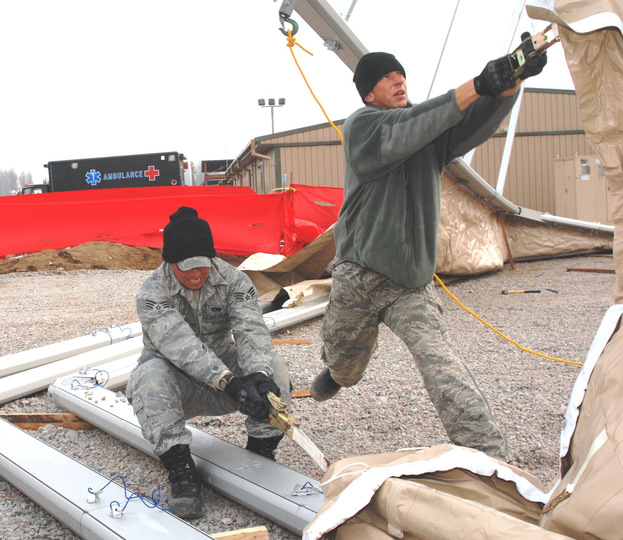 U.S. Air Force Staff Sgt. Wynn Hartson and Senior Airman Jacob Sandor, J2 Basic Expeditionary Airfield Resources team, pull the fabric into place for the front side of a new 4K dome here Jan. 16, 2010. The tents will be used to support the Airmen, Soldiers, Sailors and Marines who pass through the Transit Center. The team, deployed from the 49th Material Maintenance Squadron, Holloman Air Force Base, N.M., travels the area of responsibility building structures. (U.S. Air Force photo/Senior Master Sgt. Mike Litsey/Released)
