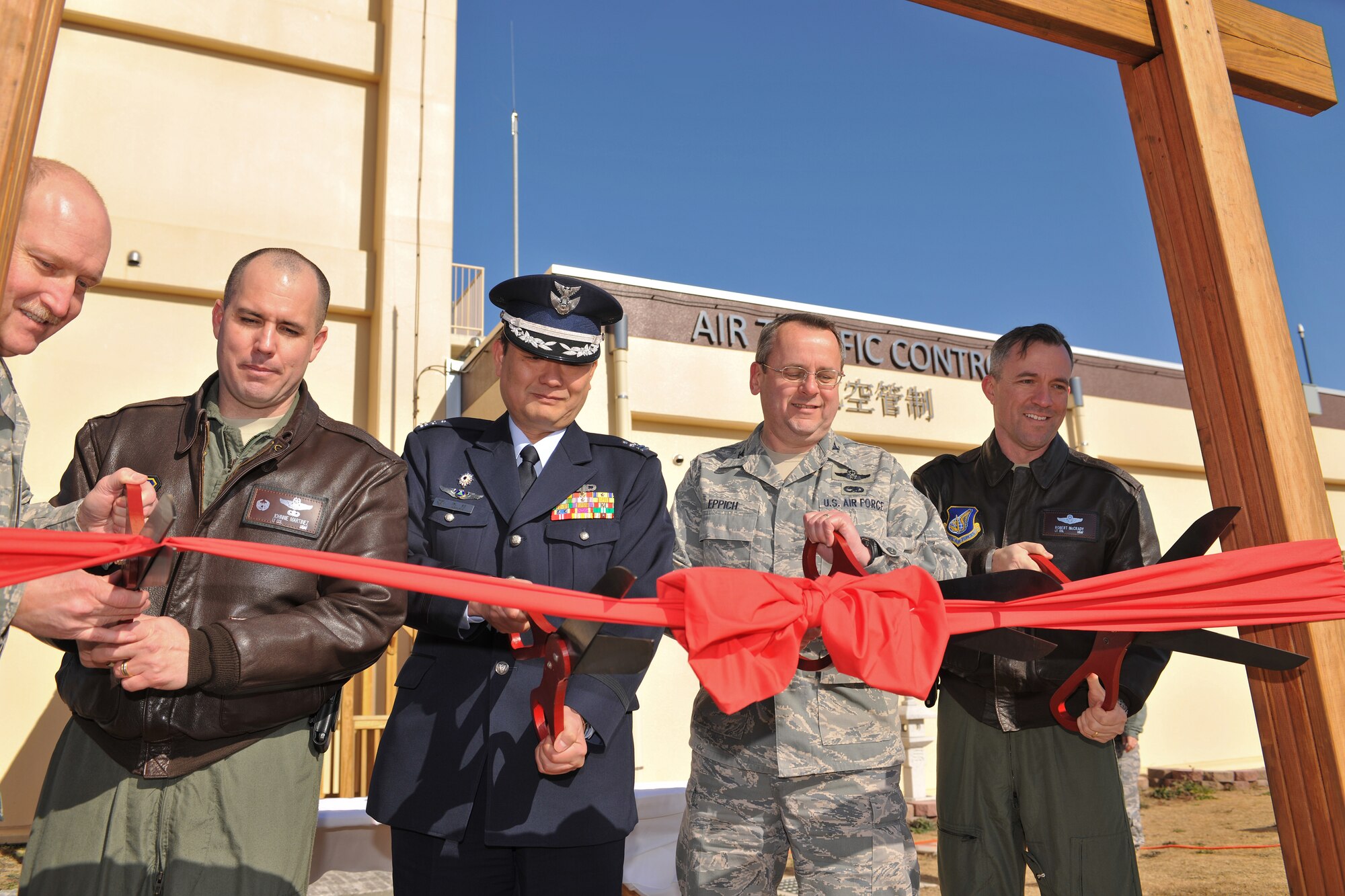 YOKOTA AIR BASE, Japan -- (from left to right) Lt. Col. Johnnie Martinez, 374th Operation Support Squadron commander, Col. Tatsuto Kimura, the commander of Air Traffic Control Group Iruma Air Base, Col. Frank Eppich, 374th Airlift Wing vice-commander, and Lt. Col. Robert McCrady, 374th Operation Group vice-commander, prepare cut a ribbon signifying the opening of Yokota's new Air Traffic Control tower and RAPCON, here, Jan. 22. (U.S. Air Force photo/Osakabe Yasuo)
