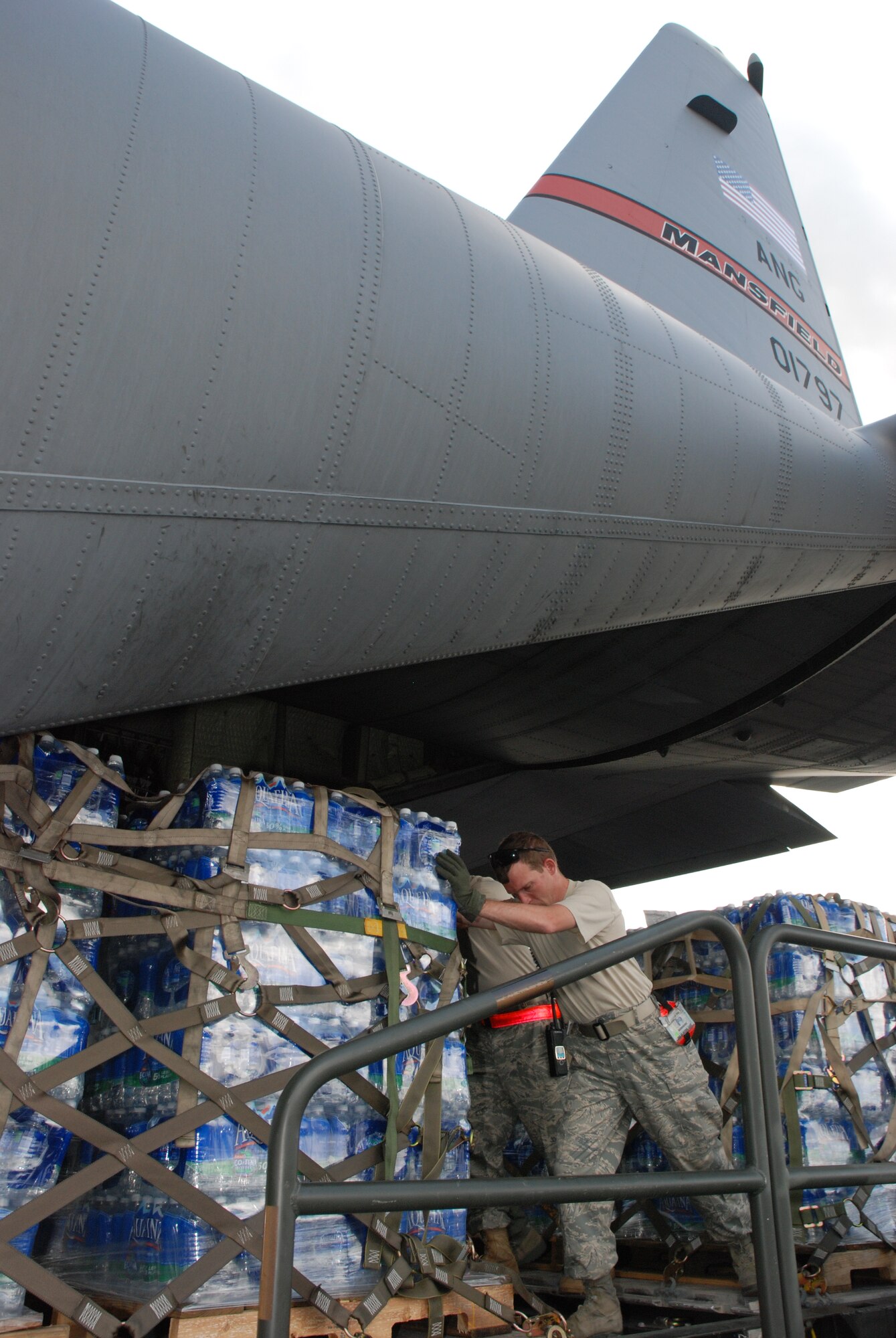 Master Sgt. Scott Smeltzer, 35th Expeditionary Airlift Squadron crew chief, assigned from the 179th Airlift Wing, Mansfield, Ohio, assists loadmasters and aerial port Airmen at Homestead Air Reserve Base, Fla. with loading pallets of water and supplies for delivery to the Dominican Republic in support of the earthquake victims in Haiti. The Ohio Air National Guard's C-130 aircrew was performing its Coronet Oak rotation at Muñiz Air National Guard Base, Puerto Rico. The Coronet Oak C-130s were the first military aircraft to deliver supplies to Haiti after the earthquake. (U.S. Air Force photo/Master Sgt. Stan Coleman)
