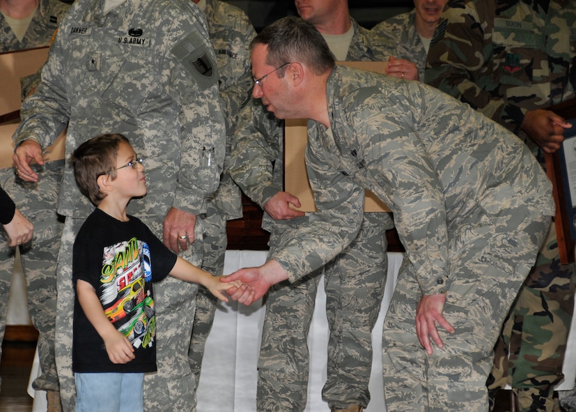 Brig. Gen. John Owen shakes the hand of a child of member of the 131st Bomb Wing during a Hometown Heroes Salute ceremony at Ritenour High School Jan. 23. The ceremony was held as a way to honor Airmen and their families for their dedication and service during deployments in support of Operations Enduring Freedom, Iraqi Freedom and Noble Eagle. (Photo by Master Sgt. Mary-Dale Amison)