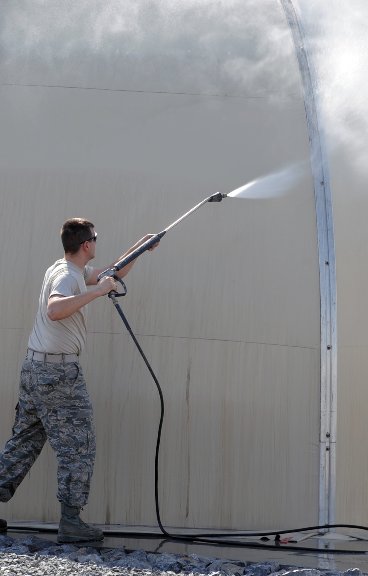 Senior Airman Jeffrey Campbell, from the 380th Expeditionary Logistics Readiness Squadron, hoses down a shelter at a non-disclosed location in Southwest Asia on Jan. 22, 2010.  Airman Campbell was removing dirt and debris as part of an effort that helps preserve the structure. He is deployed from the New Jersey Air National Guard's 177th Logistics Readiness Squadron at Atlantic City International Airport, N.J., and his hometown is Williamstown, N.J.  (U.S. Air Force Photo/Tech. Sgt. Scott T. Sturkol/Released)
