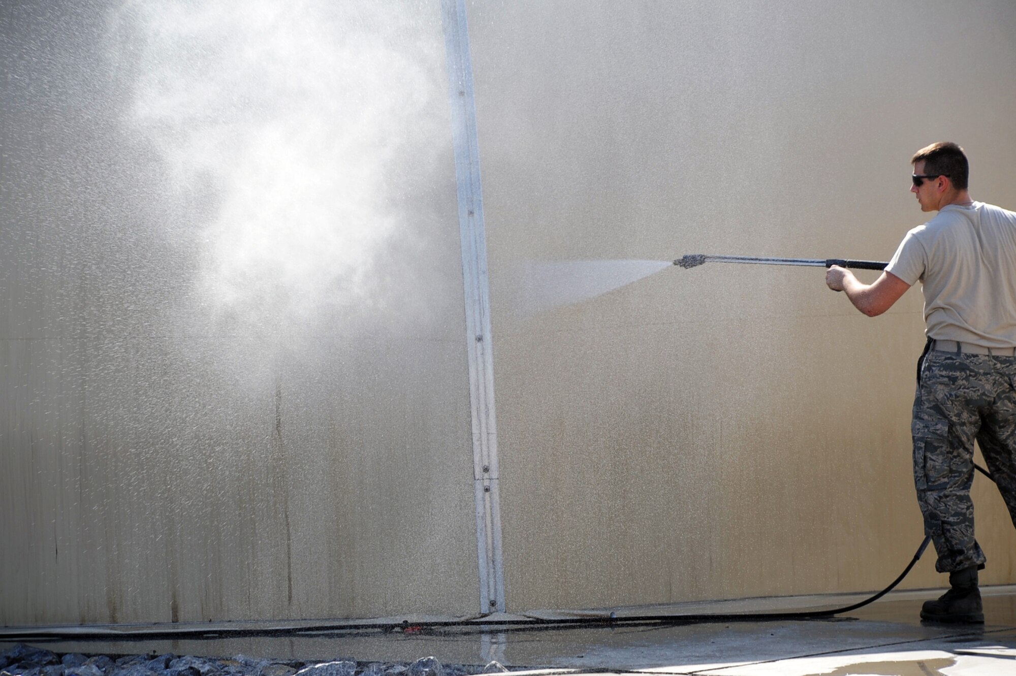 Senior Airman Jeffrey Campbell, from the 380th Expeditionary Logistics Readiness Squadron, hoses down a shelter at a non-disclosed location in Southwest Asia on Jan. 22, 2010.  Airman Campbell was removing dirt and debris as part of an effort that helps preserve the structure. He is deployed from the New Jersey Air National Guard's 177th Logistics Readiness Squadron at Atlantic City International Airport, N.J., and his hometown is Williamstown, N.J.  (U.S. Air Force Photo/Tech. Sgt. Scott T. Sturkol/Released)