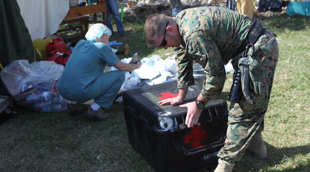 Chief Petty Officer Kenny Mathiesen, leading chief petty officer for Battalion Aid Station, Battalion Landing Team, 3rd Battalion, 2nd Marine Regiment, 22nd Marine Expeditionary Unit, unpacks medical supplies at a Canadian medical clinic just outside of Leogane, Haiti, Jan. 22, 2010. The corpsmen of the BLT dropped off various medical supplies and surgical instruments to help aid the clinic in servicing sick and injured locals.