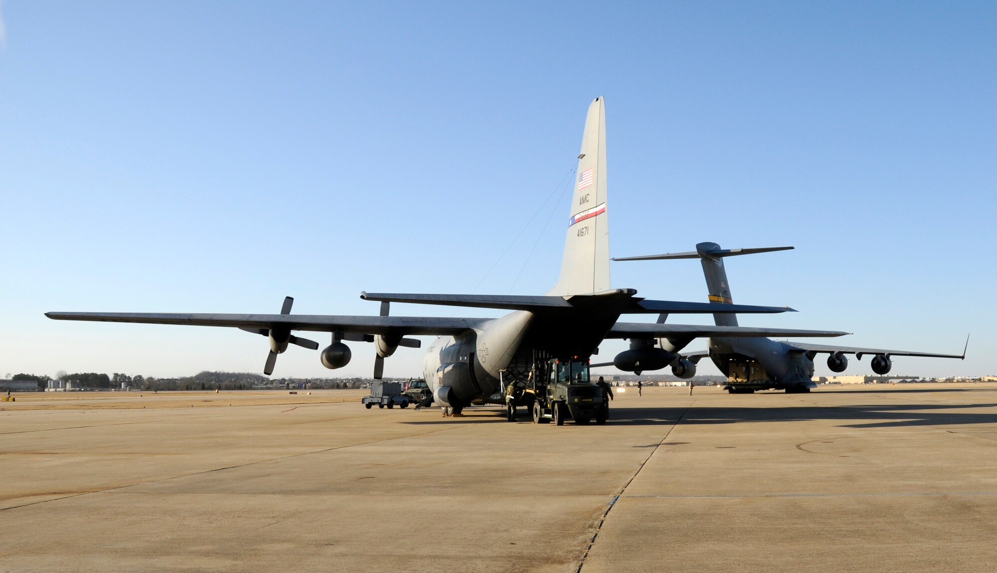 A C-17 and C-130 sit on the ramp at the 188th Fighter Wing Jan. 25. Both aircraft were loaded with cargo containing the 188th's Disaster Relief Beddown Set (DRBS). The 188th was tasked with deploying its DRBS in support of Operation Unified Response. The DRBS is a 188th asset that supports 150 personnel. It includes one all-terrain forklift, billets, shower and latrine facilities, water purification capabilities, a kitchen and self-help laundry machines. The DRBS will be used to house relief personnel from Expeditionary Medical Support, which will help provide medical care to Haiti earthquake victims. (U.S. Air Force Photo by Capt. Heath Allen/188th Fighter Wing Public Affairs)