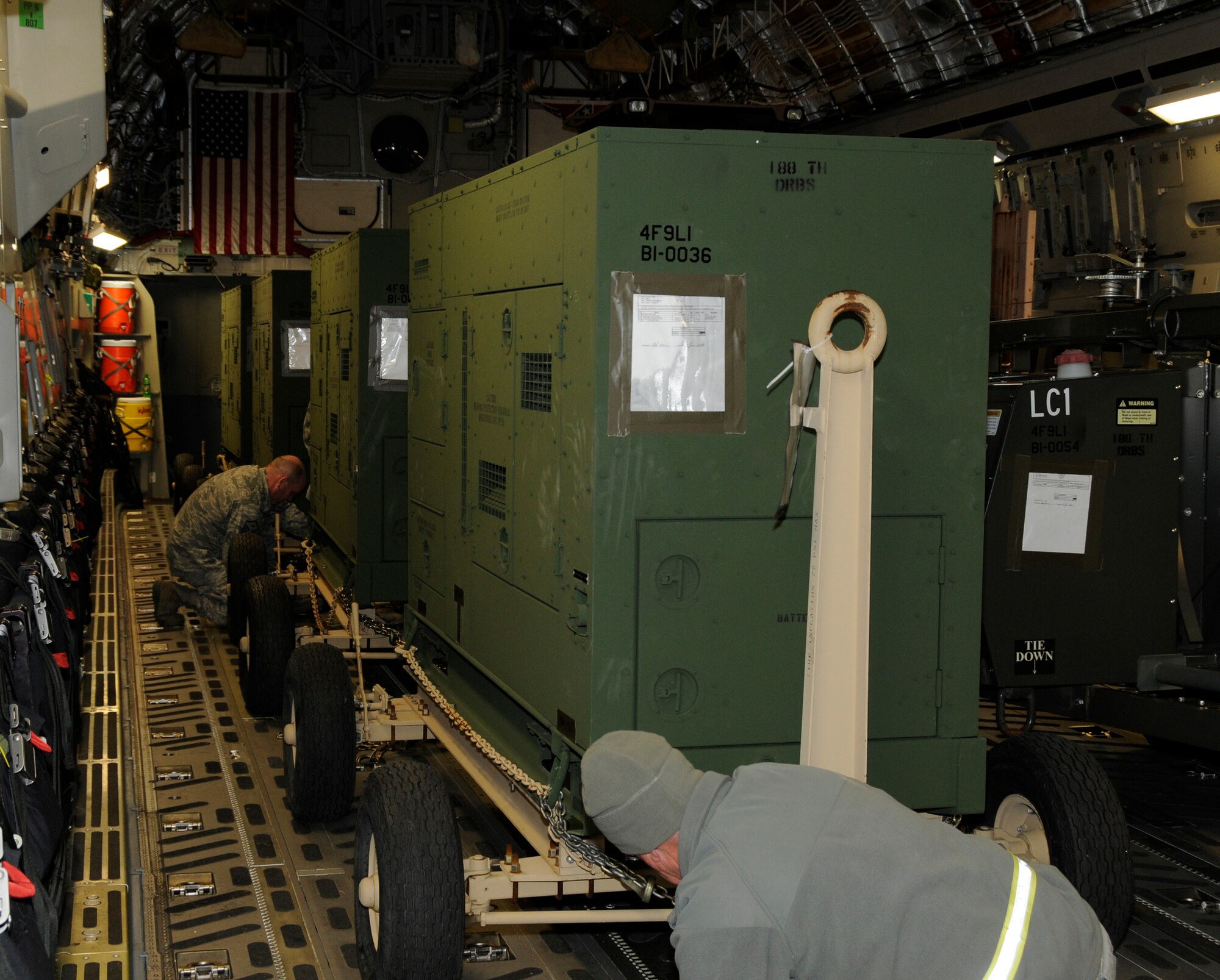 Airmen with the 188th Fighter Wing work to tie down billets on board a C-17 Jan. 25. The billets are part of the 188th's Disaster Relief Beddown Set (DRBS). The 188th was tasked with deploying its DRBS in support of Operation 
Unified Response. The DRBS is a 188th asset that supports 150 personnel. It includes one all-terrain forklift, billets, shower and latrine facilities, water purification capabilities, a kitchen and self-help laundry machines. The DRBS will be used to house relief personnel from Expeditionary Medical Support, which will help provide medical care to Haiti earthquake victims. (U.S. Air Force Photo by Capt. Heath Allen/188th Fighter Wing Public Affairs)