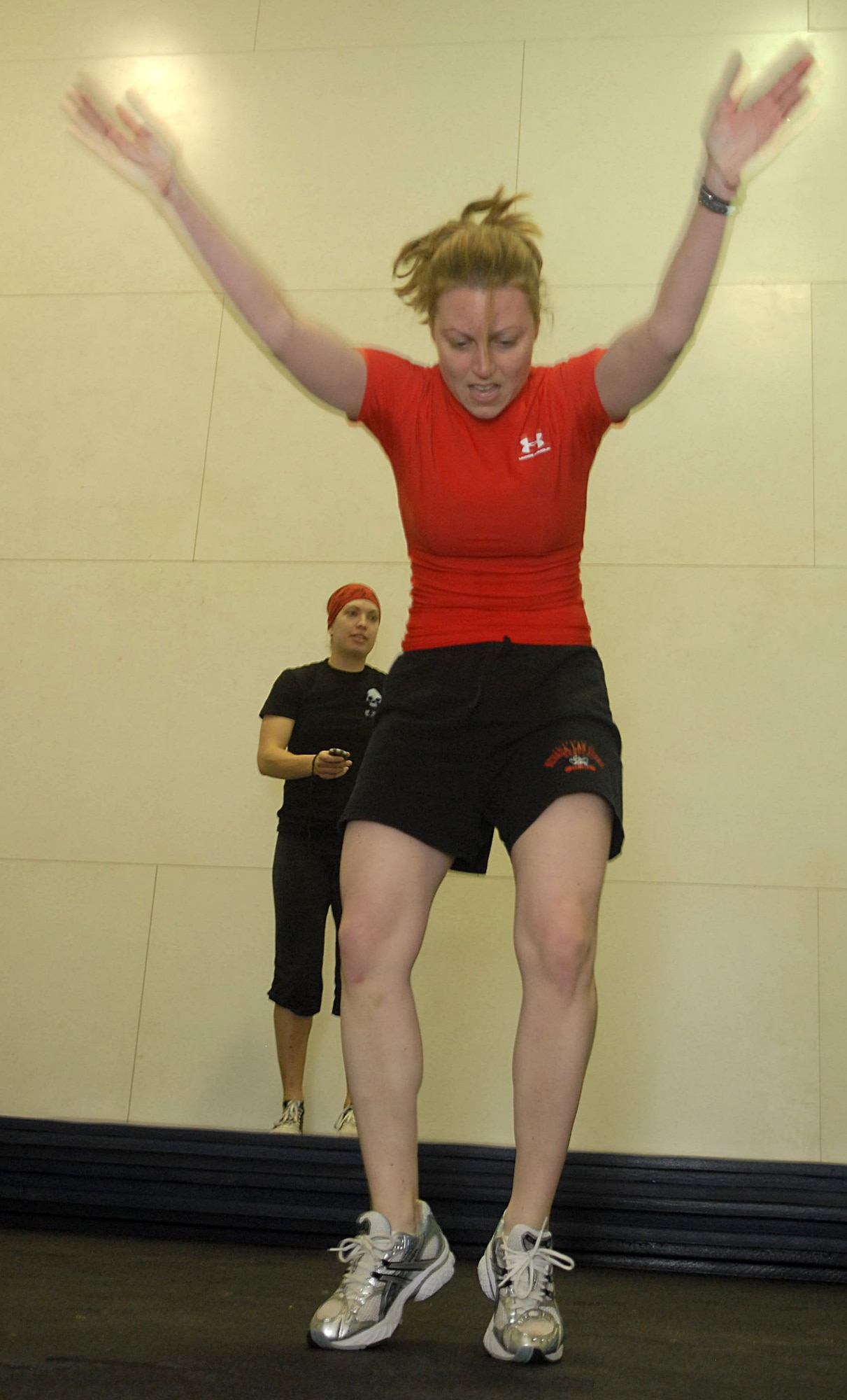 KUNSAN AIR BASE, Republic of Korea -- 1st Lt. Kari Kundert, 8th Operations Group, keeps an eye on time while 1st Lt. Melissa Thurman, 8th Fighter Wing, performs burpees during a CrossFit work out at the fitness Center Jan. 23. CrossFit combines aerobic workouts with strength training to increase strength, flexibility, agility and endurance. (U.S. Air Force photo/Senior Airman Roy Lynch)