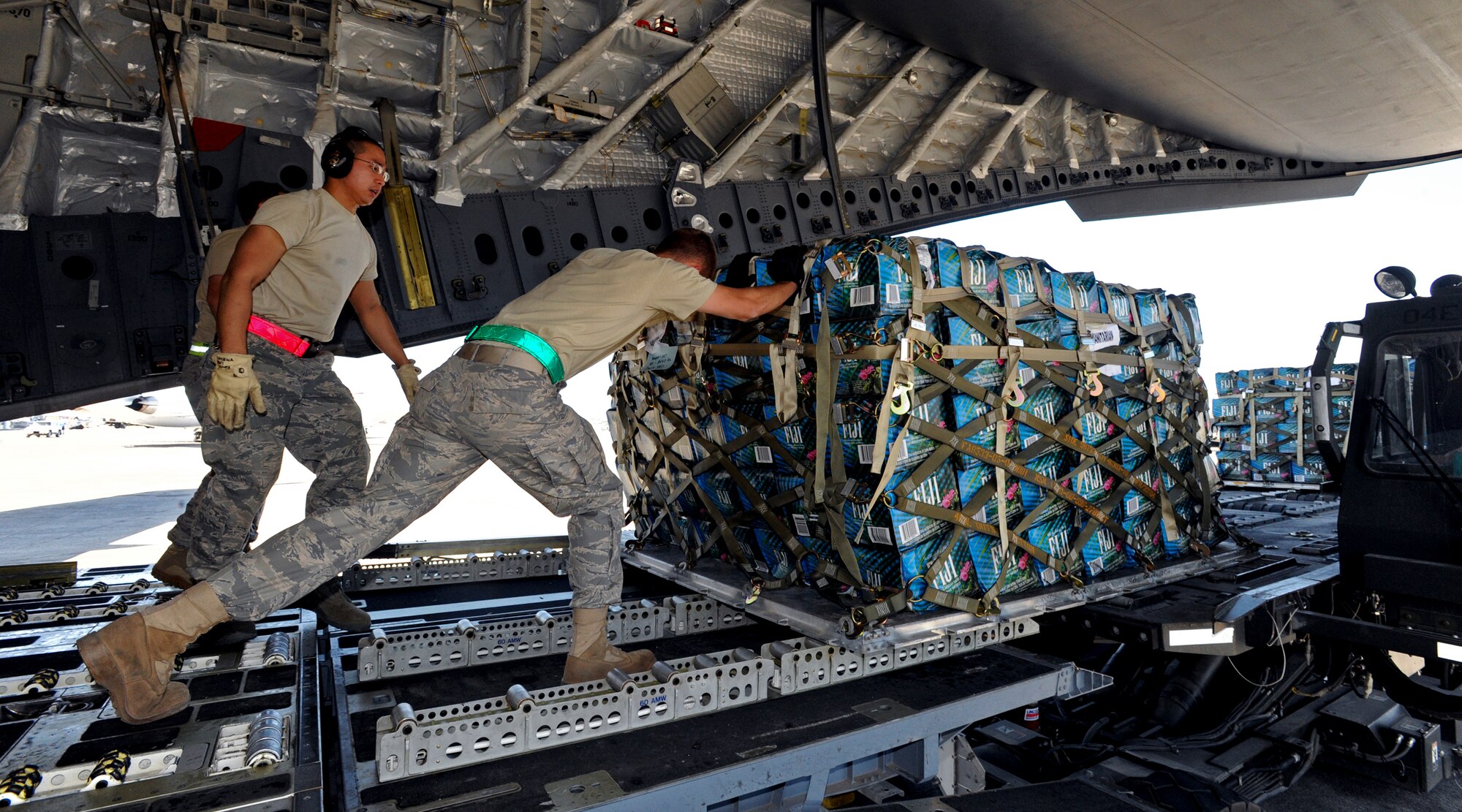 PORT-AU-PRINCE, Haiti -- Airmen push pallets of water off of a C-17 flown by pilots from the 517th Airlift Squadron from Elmendorf Air Force Base, Jan. 23. The pallets were brought from Pope Air Force Base N.C., to aid in the Haiti relief effort. (U.S. Air Force photo/Senior Airman Laura Turner)