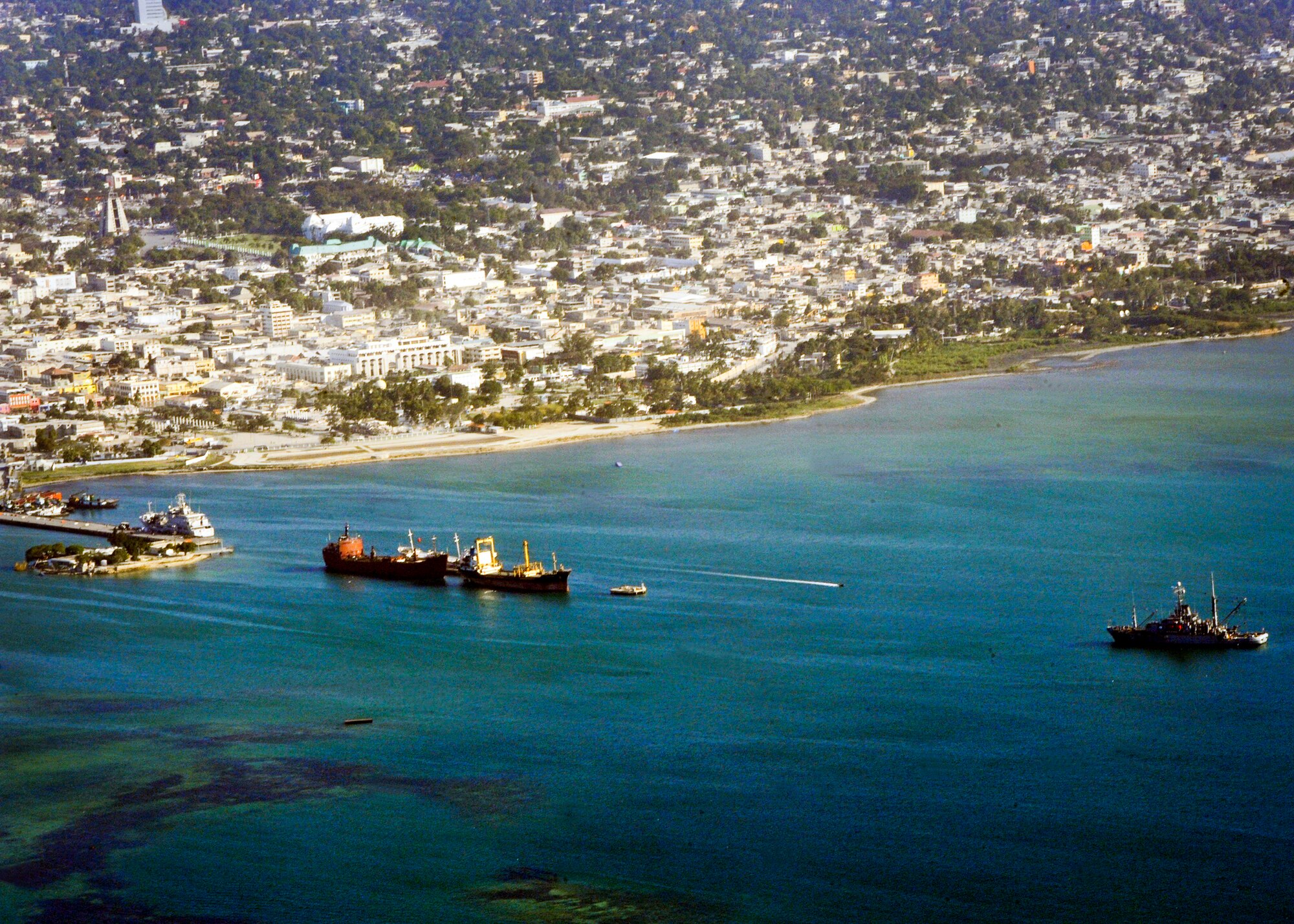 PORT-AU-PRINCE, Haiti -- The view from a C-17 Globemaster III assigned to the 517th Airlift Squadron, Elmendorf Air Force Base, shows ships moving to in aid earthquake shaken Haiti Jan. 21. The C-17 brought two Humvees and a water tank to aid in the Haiti relief effort. (U.S. Air Force photo/Senior Airman Laura Turner)