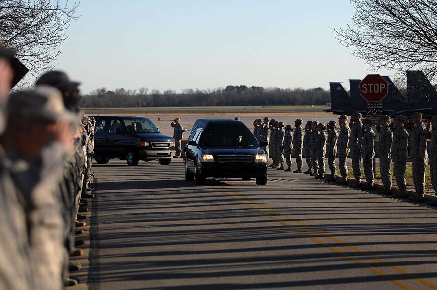 SEYMOUR JOHNSON AIR FORCE BASE, N.C. -- Members from the 4th Fighter Wing salute as the hearse carrying the remains of Tech. Sgt. Adam Ginett passes during a dignified transfer ceremony on Seymour Johnson Air Force Base, N.C., Jan. 25, 2010. Sergeant Ginett's family was on hand to witness the ceremony along with base leadership and other EOD service members. (U.S. Air Force photo/Senior Airman Ciara Wymbs)