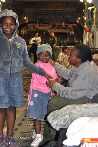 Alene, right, and her granddaughters, ages 9 and 6, travel from Port-au-Prince, Haiti, to Orlando, Fla., aboard a C-17 aircraft Jan. 22. The threesome joined 51 other passengers en route to the United States to reunite with extended family members. (U.S. Air Force photo/Bryan Magaña)