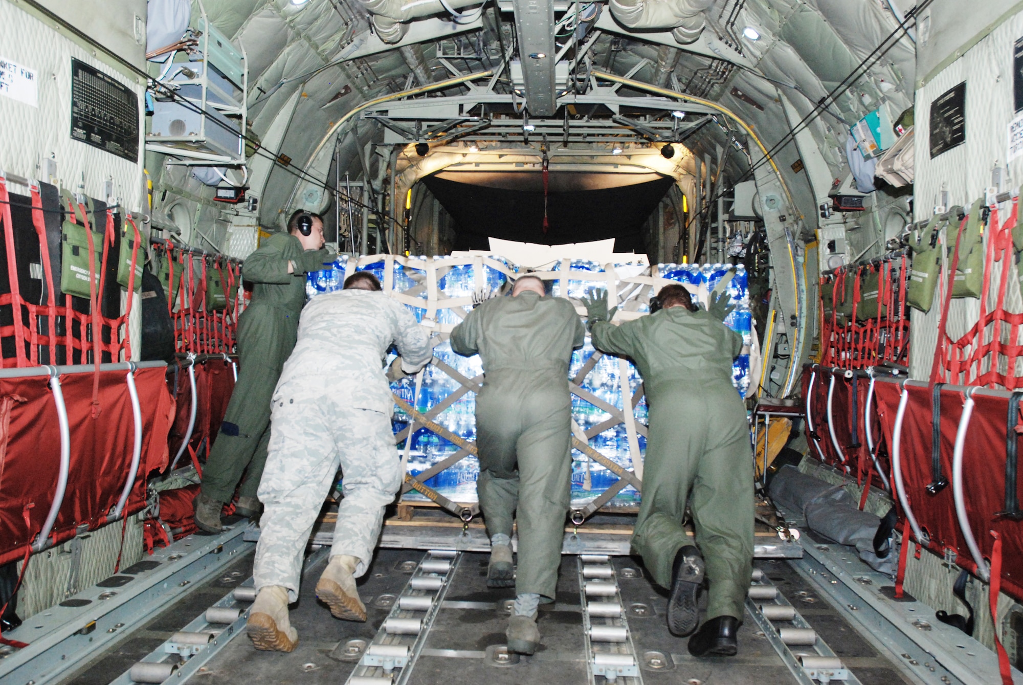 Air Force reservists, Guardsmen and active-duty Airmen assist with off-loading a pallet of water delivered to military forces in the Dominican Republic Jan. 22, 2010, assisting with the earthquake relief in Haiti. (U.S. Air Force photo/Master Sgt. Stan Coleman)
