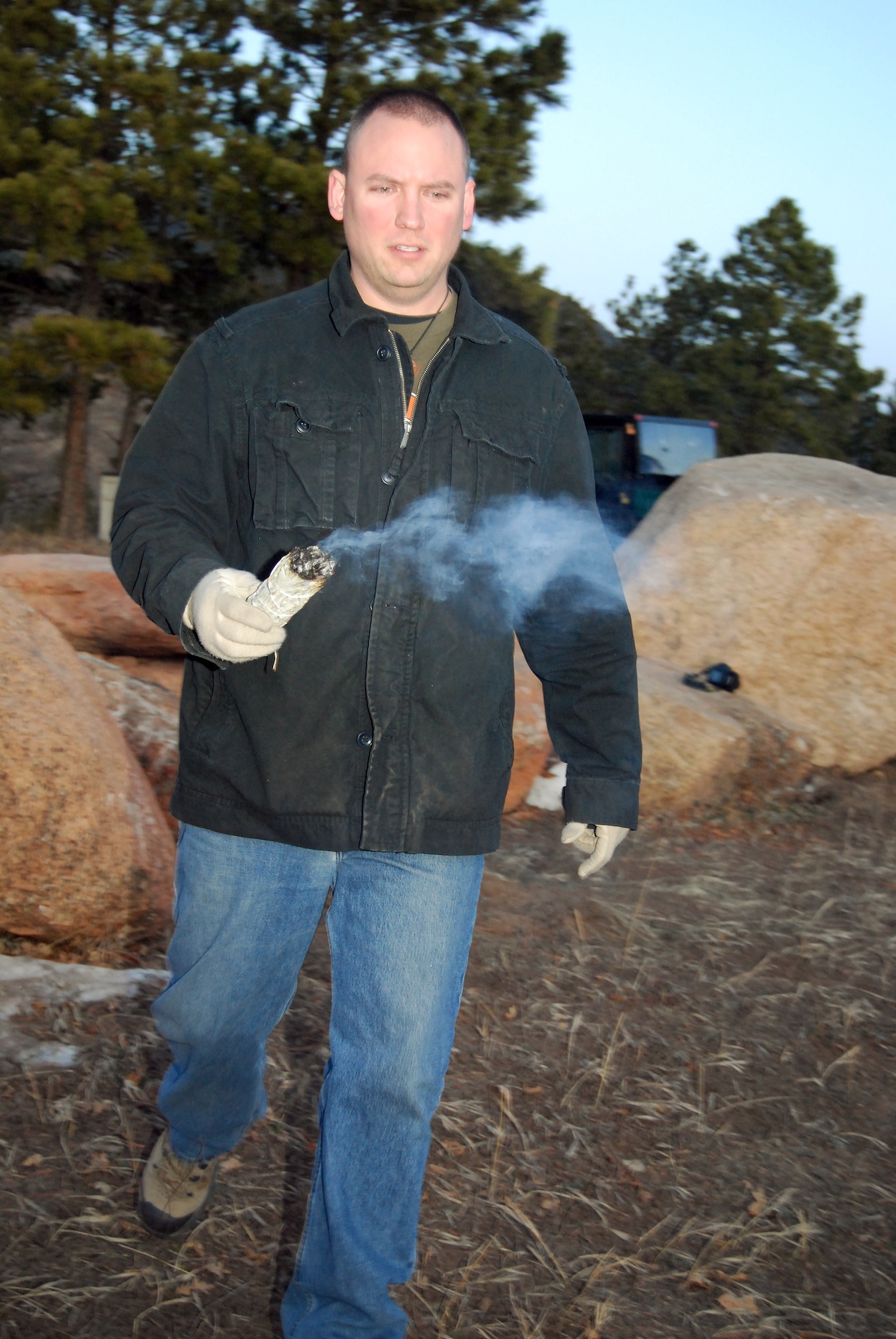 Tech. Sgt. Brandon Longcrier uses white sage to consecrate a Pagan worship area on the hill overlooking the Cadet Chapel and the Visitor Center at the Air Force Academy just after sunrise on the winter solstice, Dec. 21, 2009. The chapel is scheduled to officially designate the circle as a Pagan chapel during a dedication ceremony in March 2010. Sergeant Longcrier is the Pagan lay leader at the Academy. (U.S. Air Force photo/Staff Sgt. Don Branum)