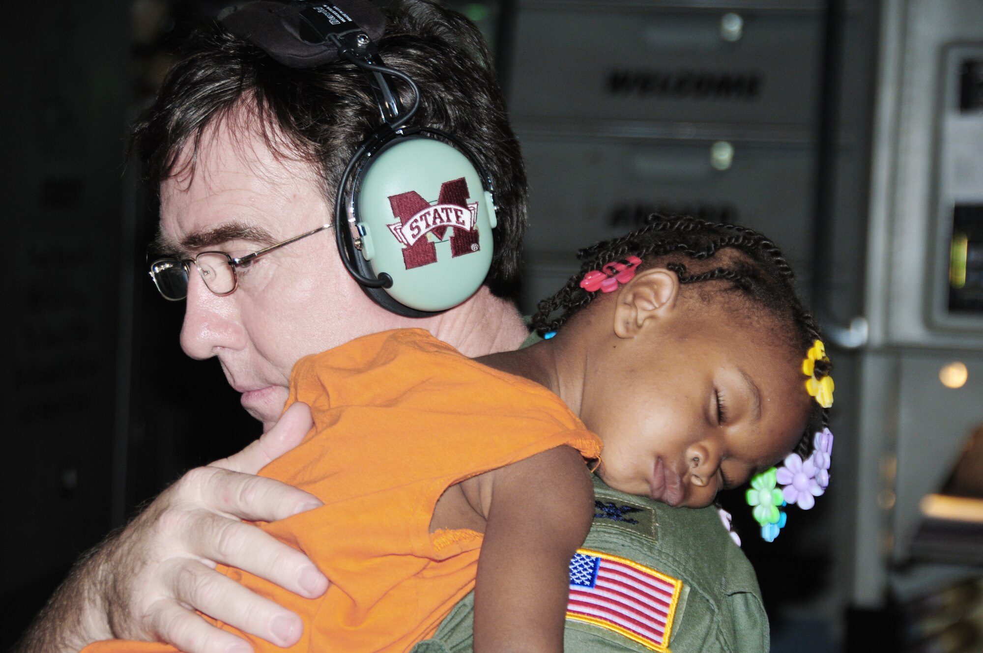 Col. Todd Wall takes time out from his job to hold a Haitian baby for a mother who was asleep from exhaustion Jan. 21, 2010, at Toussaint L?Ouverture International Airport in Port-au-Prince, Haiti. Colonel Wall is a C-17 Globemaster III cargo plane pilot. (U.S. Air Force photo/Master Sgt. Alvin Johnson)