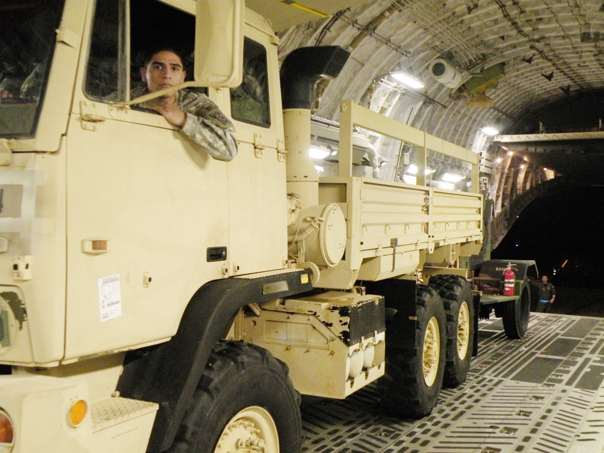 A Soldier from Fort Bragg, N.C. looks out his rear-view mirror as Staff Sgt. Gus Morse guides him and his vehicle out the back of a C-17 Globemaster III after landing in Haiti in support of Operation Unified Response during the early morning hours of Jan. 22, 2010. Sergeant Morse is a 317th Airlift Squadron loadmaster from Charleston Air Force Base, S.C. (U.S. Air Force photo/Master Sgt. Steve Staedler) 