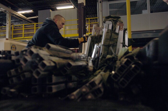 Senior Airman Zachary Wojcik stacks cots on a pallet bound for Haiti on Charleston AFB Jan. 22. The pallet included oxygen tanks and cots for the Airmen to enable them to support the relief efforts in Haiti. Their efforts include numerous tasks from rescue missions to working with the aircraft. Airman Wojcik is a fire fighter assigned to the 43rd Civil Engineer Squadron, Pope AFB, N.C. (U.S. Air Force photo/Airman 1st Class Lauren Main)