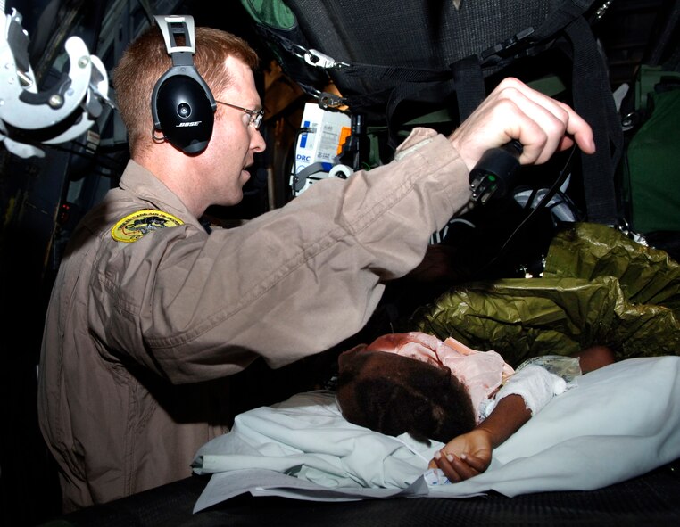 Maj. John Lynch, a physician and Critical Care Air Transport Team member, prepares a 3-year-old earthquake victim for aeromedical evacuation from Port-au-Prince, Haiti, to Fort Lauderdale, Fla. Major Lynch is with the 88th Medical Group from Wright-Patterson Air Force Base, Ohio.  (U.S. Air Force photo/2nd Lt. Anastasia Wasem) 
