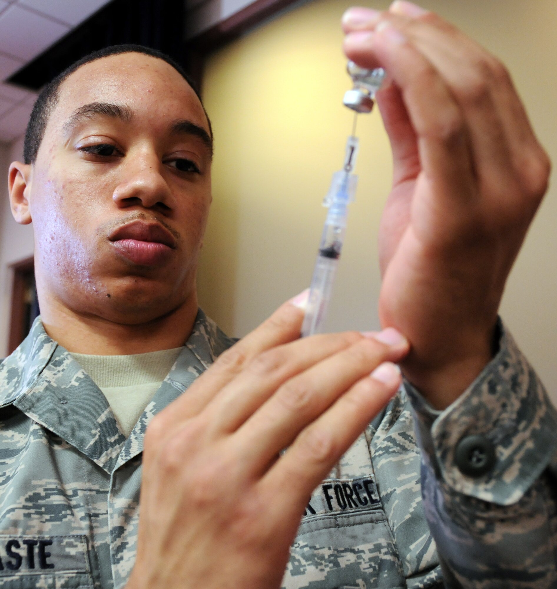 EGLIN AIR FORCE BASE, Fla. – Airman Nigel Contaste, Phase Two Aerospace Medical Services student, prepares a syringe filled with H1N1 vaccine, Jan. 22. H1N1 vaccinations are mandatory for all active duty military personnel on Eglin. The 96th Medical Group provided vaccinations to base personnel Jan 19-22 at the 9th Special Operations Squadron auditorium to help alleviate traffic and waits at the immunizations clinic. Seasonal and H1N1 are currently available to specific target groups at the immunization clinic during normal duty hours. (U.S. Air Force photo/ Airman 1st Class Anthony Jennings)