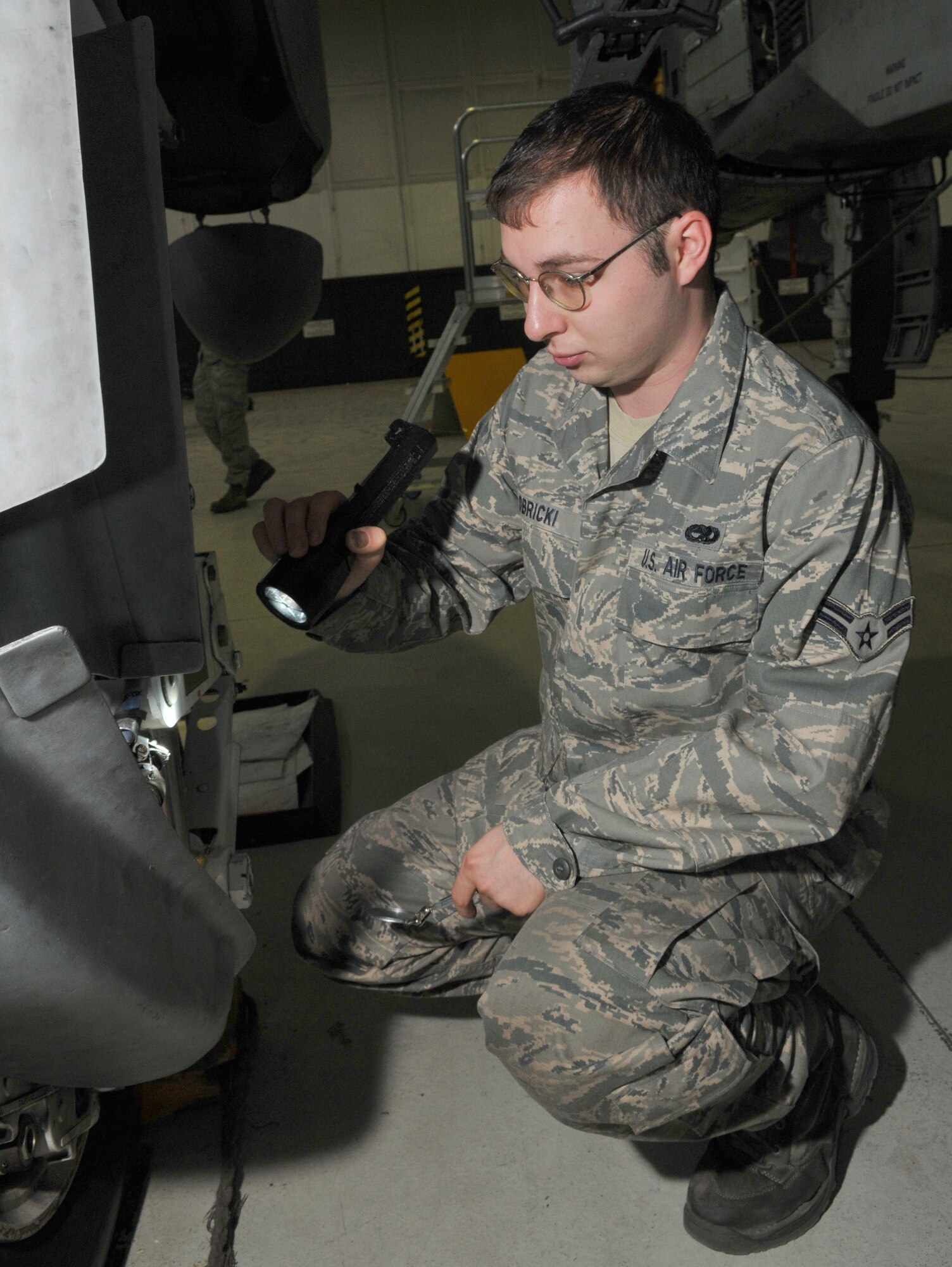 SPANGDAHLEM AIR BASE, Germany -- Airman 1st Class Michael Obricki, 52nd Equipment Maintenance Squadron, inspects an A-10 Thunderbolt II's landing gear Jan. 21 in Hangar 2. This was completed as part of the A-10's phase inspection checklist, which is separated into two phases. Within each phase, about 675 maintenance manuals called "work cards" are used to inspect different areas of the aircraft. (U.S. Air Force photo/Airman 1st Class Nick Wilson)