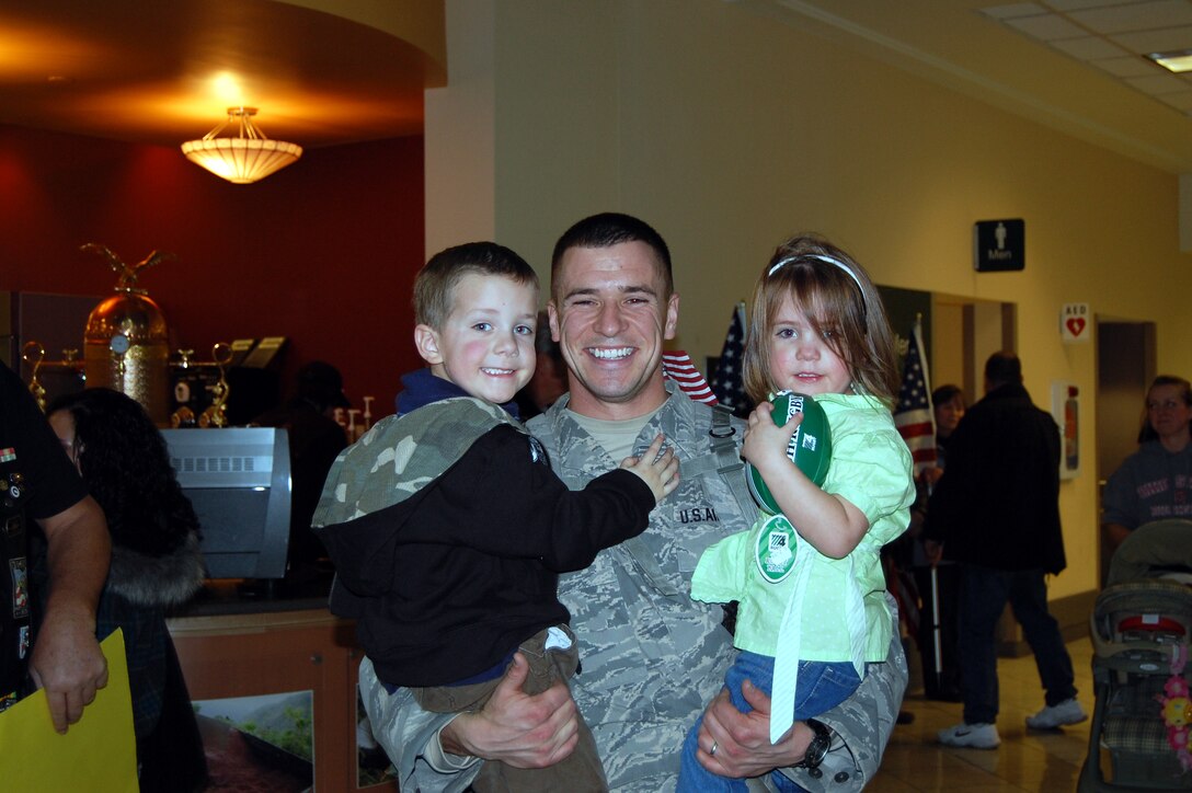 WRIGHT-PATTERSON AIR FORCE BASE, Ohio – Tech. Sgt. Ronald Lause, 445th Security Forces Squadron, greets his son, Ronald, and daughter, Ella, at the Dayton International Airport Jan. 17 upon returning from a 197-day deployment in Iraq with 12 other Airmen from his unit. While deployed the Airmen performed various security forces functions to include base security, vehicle searches, gate security, patrol, and tower duties. (U.S. Air Force photo/Maj. Cynthia Harris)