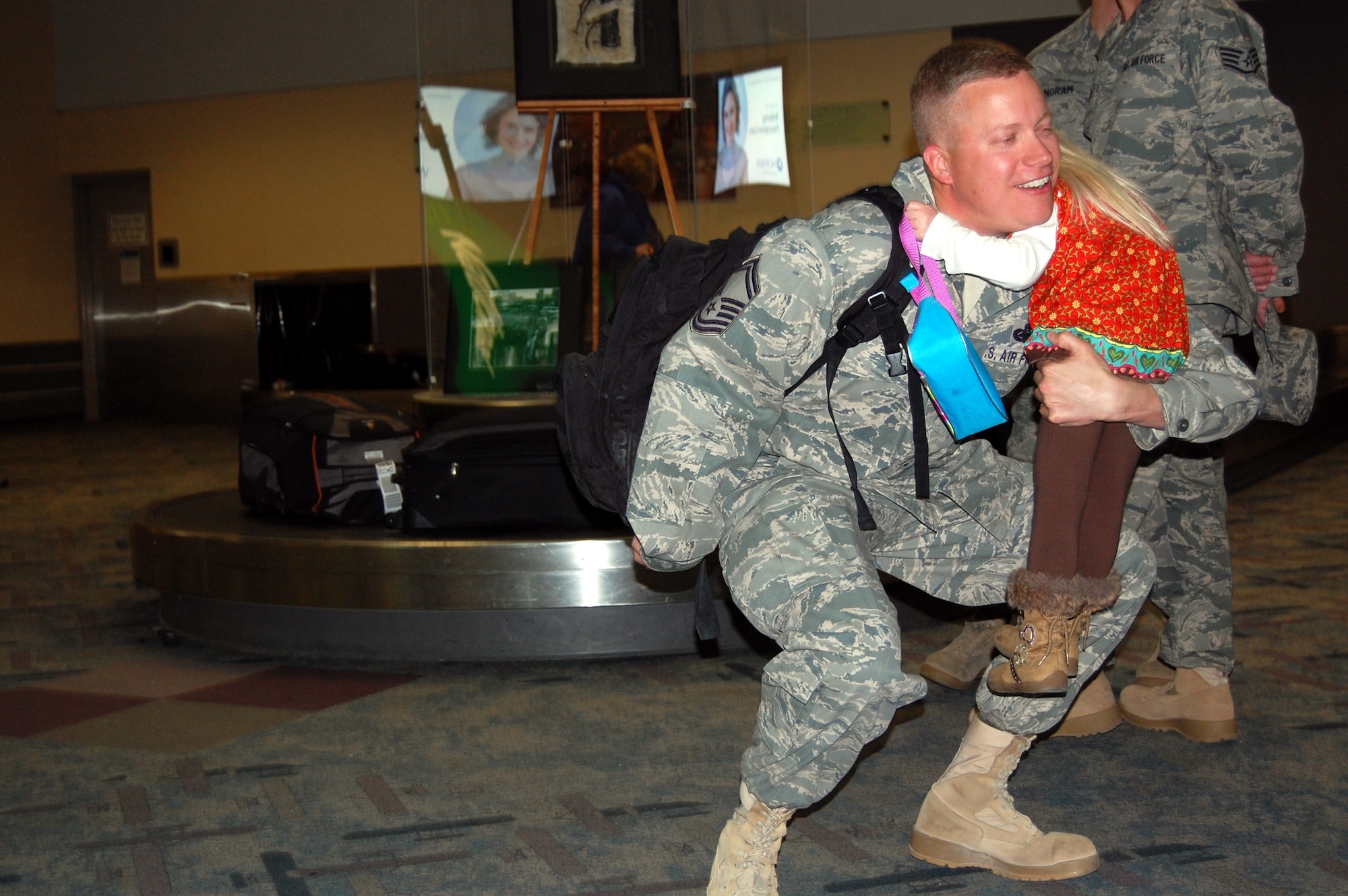 WRIGHT-PATTERSON AIR FORCE BASE, Ohio – Senior Master Sgt. David Ellis, 445th Security Forces Squadron, swoops up his daughter, Trinity Diane, as she welcomes him home at the Dayton International Airport Jan. 17. Sergeant Ellis and 12 other Airmen from the SFS just completed a 197-day deployment in Iraq.  While deployed the Airmen performed various security forces functions to include base security, vehicle searches, gate security, patrol, and tower duties. (U.S. Air Force photo/Maj. Cynthia Harris)