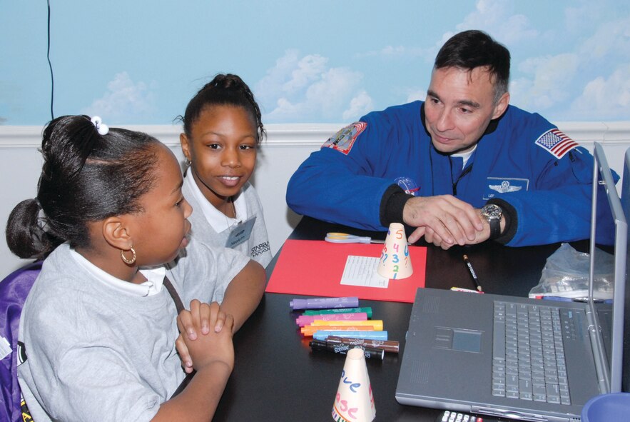 Neoletti Jackson, left, and Nykevia Crenshaw of Mrs. Jackie Allen’s fifth-grade class at Peter Crump Elementary School, speak with former Air Force pilot and NASA astronaut Lee Archambault while visiting Maxwell’s STARBASE.(Official Air Force Photo by Bennett Rock)