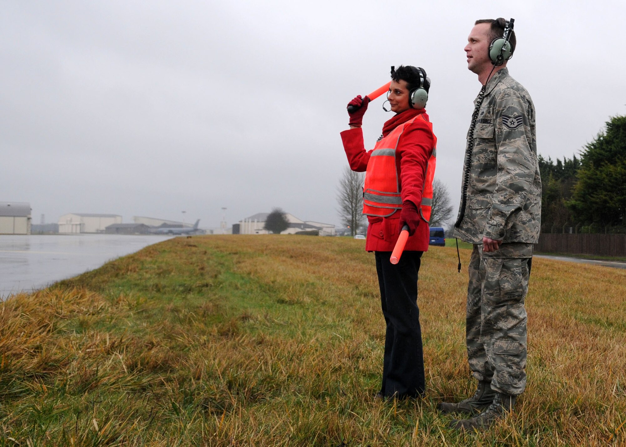 Karen Abeyasekere, 100th Air Refueling Wing Public Affairs, gives the signal to Capt. Clint Albaugh, 351st Air Refueling Squadron aircraft commander, prior to takeoff Jan. 22, 2010. Ms. Abeyasekere had the opportunity to marshal one of RAF Mildenhall's KC-135s, with the assistance of Staff Sgt. Glenn Hendrix, 100th Aircraft Maintenance Squadron, to learn more about the crew chiefs and what their job involves. (U.S. Air Force photo by Staff Sgt. Jerry Fleshman)