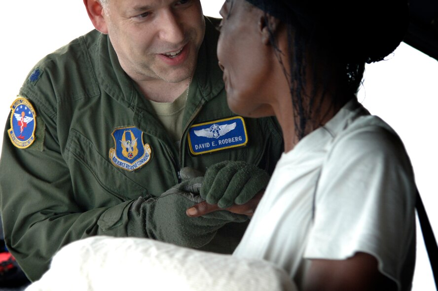 Lt. Col. David E. Rodberg, medical crew director, 94th Aeromedical Evacuation Squadron, bids farewell to one of the passengers on an aeromedical evacuation flight out of Haiti, Jan. 22-23.  In all, 18 urgent care patients, four critical-care patients and 26 attending family members were escorted by Colonel Rodberg’s team, based at Dobbins Air Reserve Base, Ga.  (U.S. Air Force photo by 2nd Lt. Nicholas Mercurio/Released)