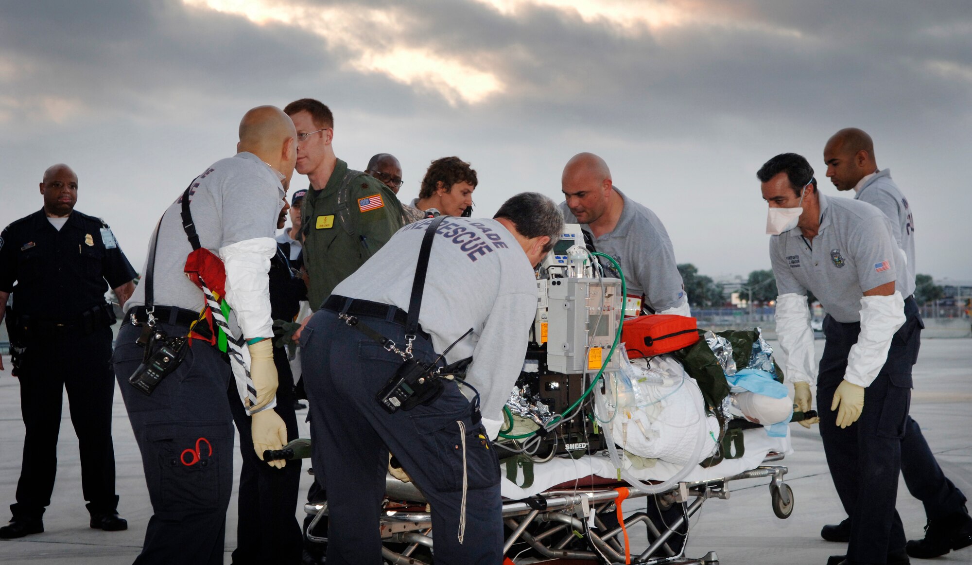 Emergency medical technicians from Miami-Dade Fire Rescue work with Air Force Critical Care Air Transport Team members to offload critical-care patients from an Air Force aeromedical evacuation flight Jan. 23 at Miami International Airport.  The CCATT team accompanied the patients from Haiti, providing critical care while airborne.  (U.S. Air Force photo by 2nd Lt. Nicholas Mercurio/Released)