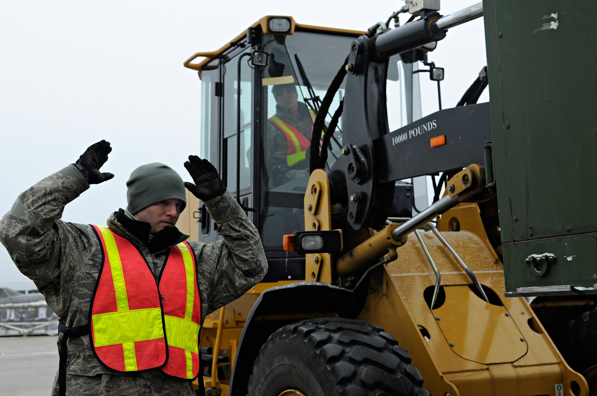 SPANGDAHLEM AIR BASE, Germany – Airman Johnny Sanes, 52nd Logistics Readiness Squadron, uses hand signals to direct Airman 1st Class Justin Shepherd, 52nd LRS, as he drives a 10,000-pound, all-terrain forklift to load equipment onto a truck during Operation Saber Crown 10-3 here Jan. 21. Airmen who worked for the cargo deployment function during the exercise were responsible for inspecting and processing cargo to be deployed. (U.S. Air Force photo/Senior Airman Benjamin Wilson)