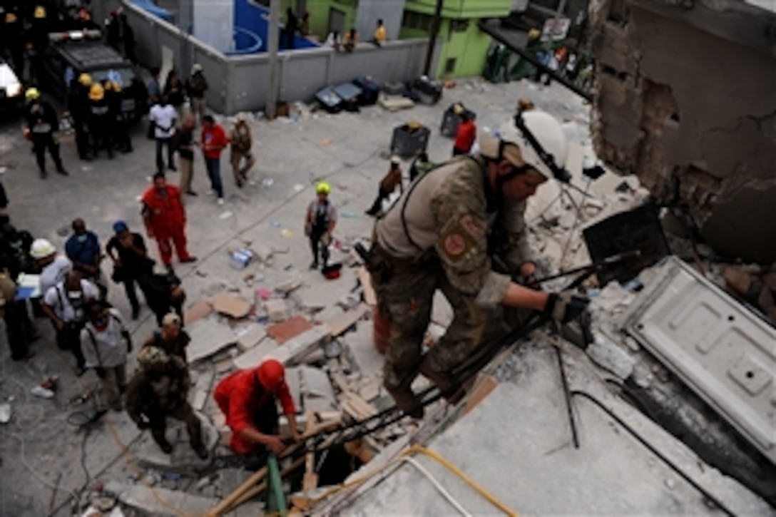 A U.S. Air Force pararescueman from the 23rd Special Tactics Squadron, Air Force Special Operations Command, Hurlburt Field, Fla., and members of various rescue teams climb a ladder to get to a 25-year-old woman who has been trapped in a collapsed building for seven days in Port-au-Prince, Haiti, on Jan. 19, 2010.  U.S. Department of Defense assets have been deployed to assist in the relief effort under way after a 7.0-magnitude earthquake hit the city on Jan. 12, 2010.  