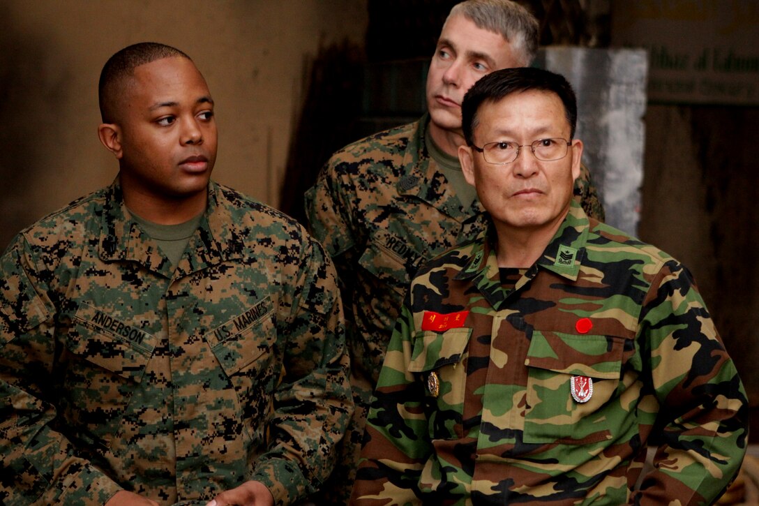 Republic of Korea Marine Sgt. Maj. Gihwi Seo (right), is escorted by Sgt. Maj. Michael Redmyer (center), Marine Forces Korea sergeant major, and Sgt. Derrick Anderson, Seo’s translator, through Camp Pendleton’s Infantry Immersion Trainer at the School of Infantry, Jan. 26. Seo visited base to get a better understanding of what it takes to successfully train and prepare U.S. Marines for deployment.