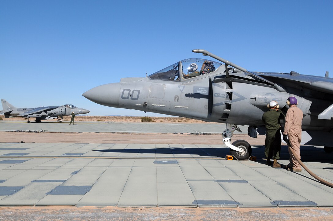 Lance Cpl. Mark Ridoloso, left, Marine Attack Squadron 311 powerline mechanic, and Lance Cpl. Michael Connor, Marine Wing Support Squadron 371 bulk fuel specialist, refuel a VMA-311 AV-8B Harrier while another prepares to take off at the Auxiliary Airfield 2 in Yuma, Ariz., Jan. 25, 2010. AUX-2 is an aircraft carrier flight deck replica, which squadrons use to practice carrier operations before working off of an actual carrier. VMA-311 trained at AUX-2 Jan. 25-28, 2010, in preparation for their carrier qualification aboard the USS Peleliu in February 2010. The squadron is scheduled to deploy to the Peleliu with the 15th Marine Expeditionary Unit in May 2010. Part of the squadron deployed to Japan with the 31st MEU earlier this month.