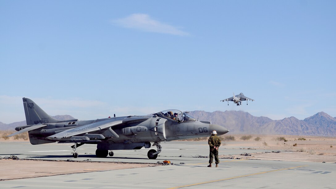 A Marine Attack Squadron 311 AV-8B Harrier takes off while another waits to taxi to the refueling point at the Auxiliary Airfield 2 in Yuma, Ariz., Jan. 25, 2010. AUX-2 is a replica of the deck of an amphibious assault ship, on which squadrons practice before working off of an actual ship at sea. The squadron started training at AUX-2 Jan. 26-28, 2010, in preparation for their carrier qualification aboard the USS Peleliu in February 2010. The squadron is scheduled to deploy to the Peleliu with the 15th Marine Expeditionary Unit in May 2010. Part of the squadron deployed to Japan with the 31st MEU in early January 2010.