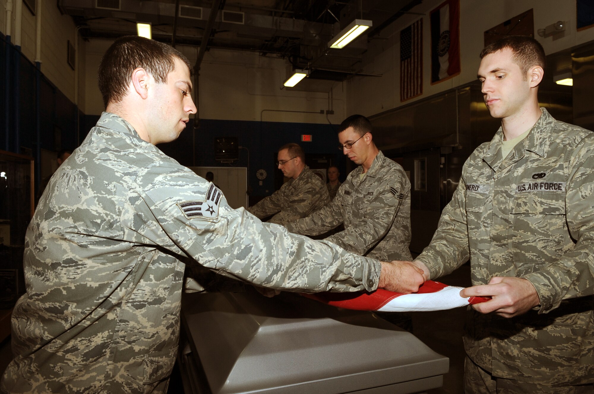 Whiteman Honor Guard members Senior Airman Geoffrey Russel, 509th Civil Engineer Squadron, and Senior Airman Cory Reinerd, 509th Aircraft Maintenance Squadron, ceremoniously fold the American flag as they practice for a funeral detail, here Tuesday, Jan. 26.  The Honor Guard provides a final tribute on behalf of a grateful Nation, for those who have served their country in the Air Force.  (U.S. Air Force Photo / Senior Airman Corey Todd) (Released)