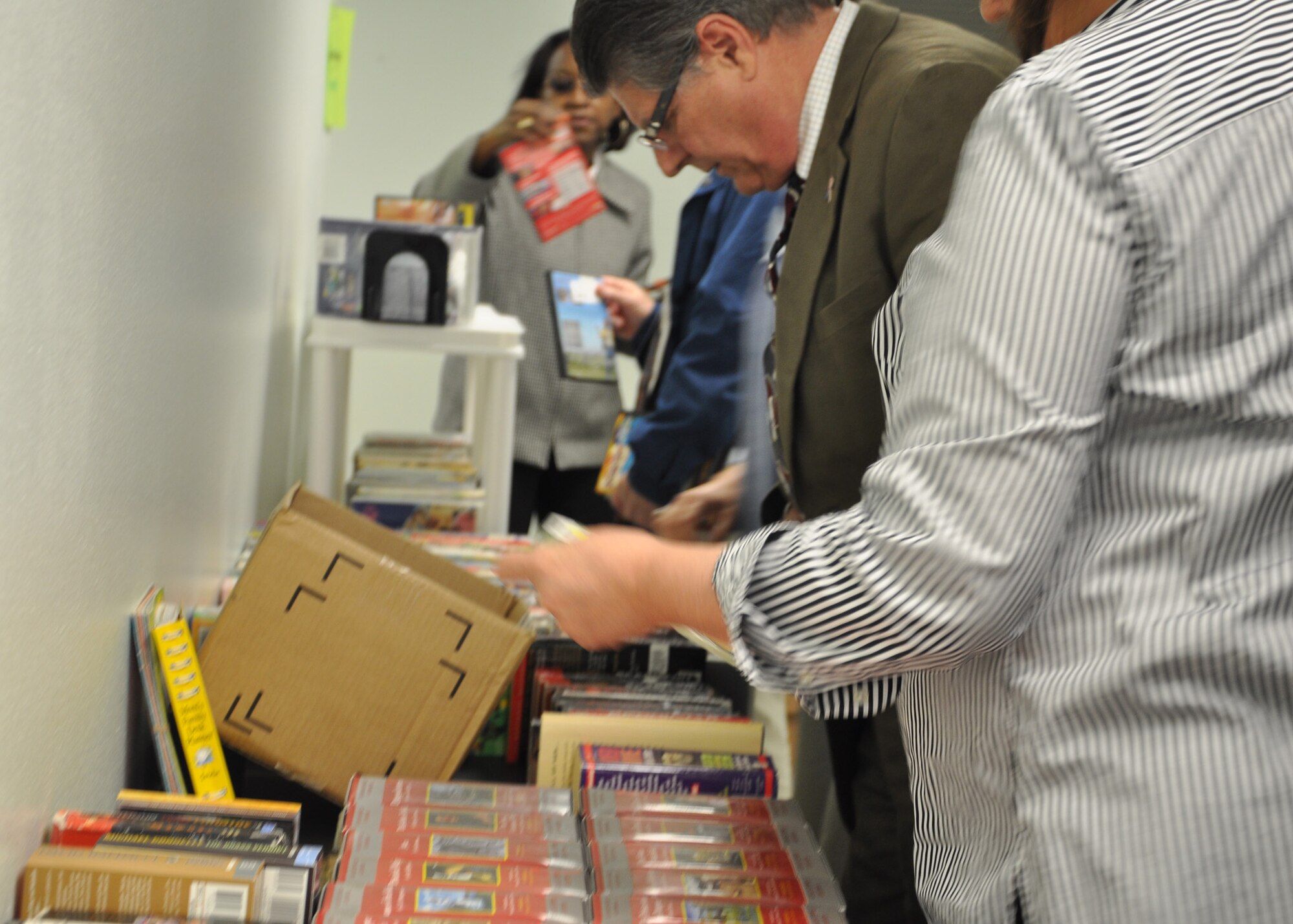 Shoppers look through discounted books at the Eglin Library Jan. 27. The book sale is held quarterly by the Eglin Officers’ Spouses’ Club. The money raised from the sales of the used books, audiotapes and movies will be used by club to help base and local charities. Many shoppers filled laundry baskets full with books that  sold for as little as 50 cents. (U.S. Air Force Photo/Ashley M. Wright)