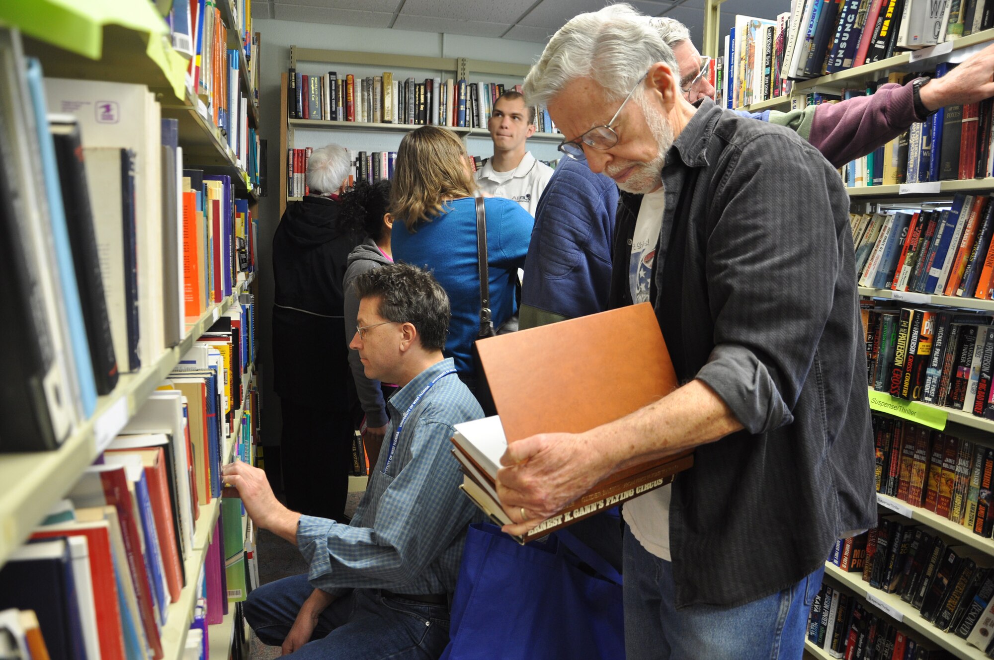 Shoppers look through discounted books at the Eglin Library Jan. 27. The book sale is held quarterly by the Eglin Officers’ Spouses’ Club. The money raised from the sales of the used books, audiotapes and movies will be used by club to help base and local charities. Many shoppers filled laundry baskets full with books that  sold for as little as 50 cents. (U.S. Air Force Photo/Ashley M. Wright)