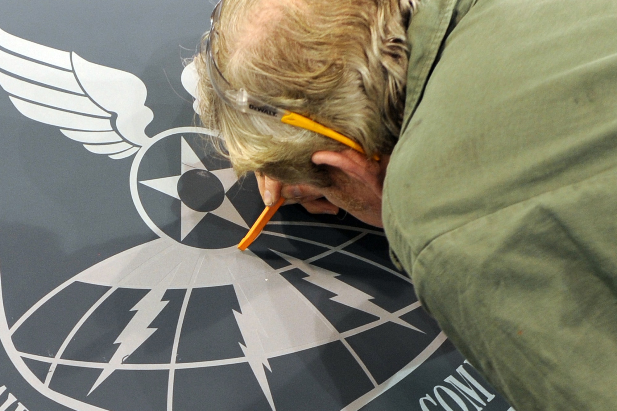 WHITEMAN AIR FORCE BASE, Mo. - Brian Geary, 509th Maintenance Squadron structural maintenance low-observable technician, uses a rubber tool to peel off the stencil from around the newly-sprayed Air Force Global Strike Command patch on a B-2 Spirit, Jan. 25, 2010. On Feb. 1, 2010, Whiteman AFB and its arsenal of 20 B-2 bombers will change commands from Air Combat Command to AFGSC. The mission of AFGSC is to "develop and provide combat-ready forces for nuclear deterrence and global strike operations -- safe -- secure -- credible to support the President of the United States and combatant commanders." (U.S. Air Force photo by Airman 1st Class Carlin Leslie) (Released)

