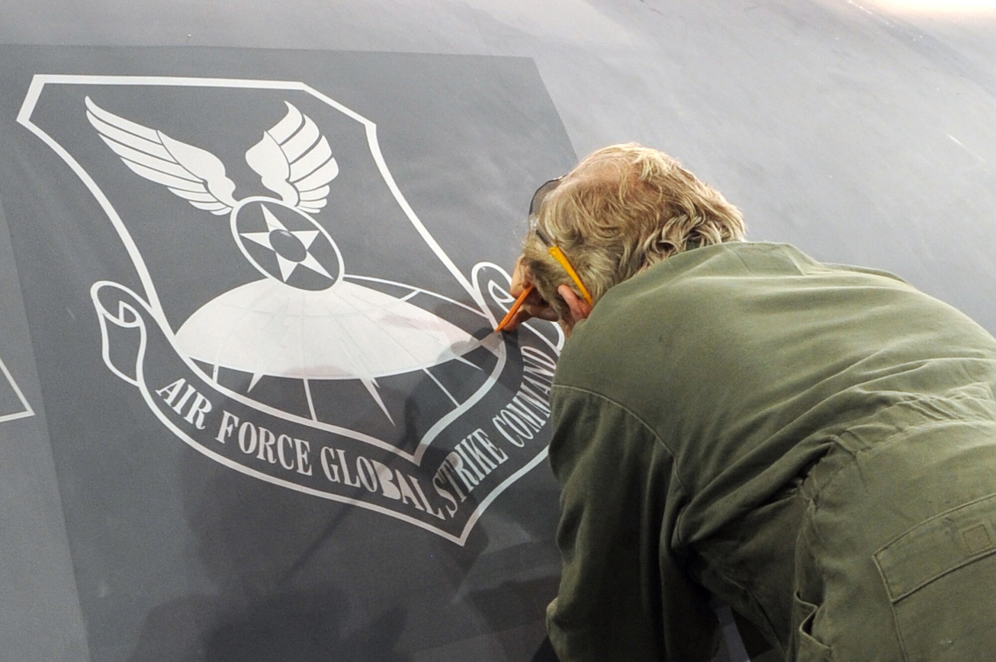 WHITEMAN AIR FORCE BASE, Mo. - Brian Geary, 509th Maintenance Squadron structural maintenance low-observable technician, carefully peels off the stencil from around the newly painted Air Force Global Strike Command patch on a B-2 Spirit, Jan. 25, 2010. On Feb. 1, 2010, Whiteman AFB and its arsenal of 20 B-2 bombers will change commands from Air Combat Command to AFGSC. The mission of AFGSC is to "develop and provide combat-ready forces for nuclear deterrence and global strike operations -- safe -- secure -- credible to support the President of the United States and combatant commanders." (U.S. Air Force photo by Airman 1st Class Carlin Leslie) (Released)
